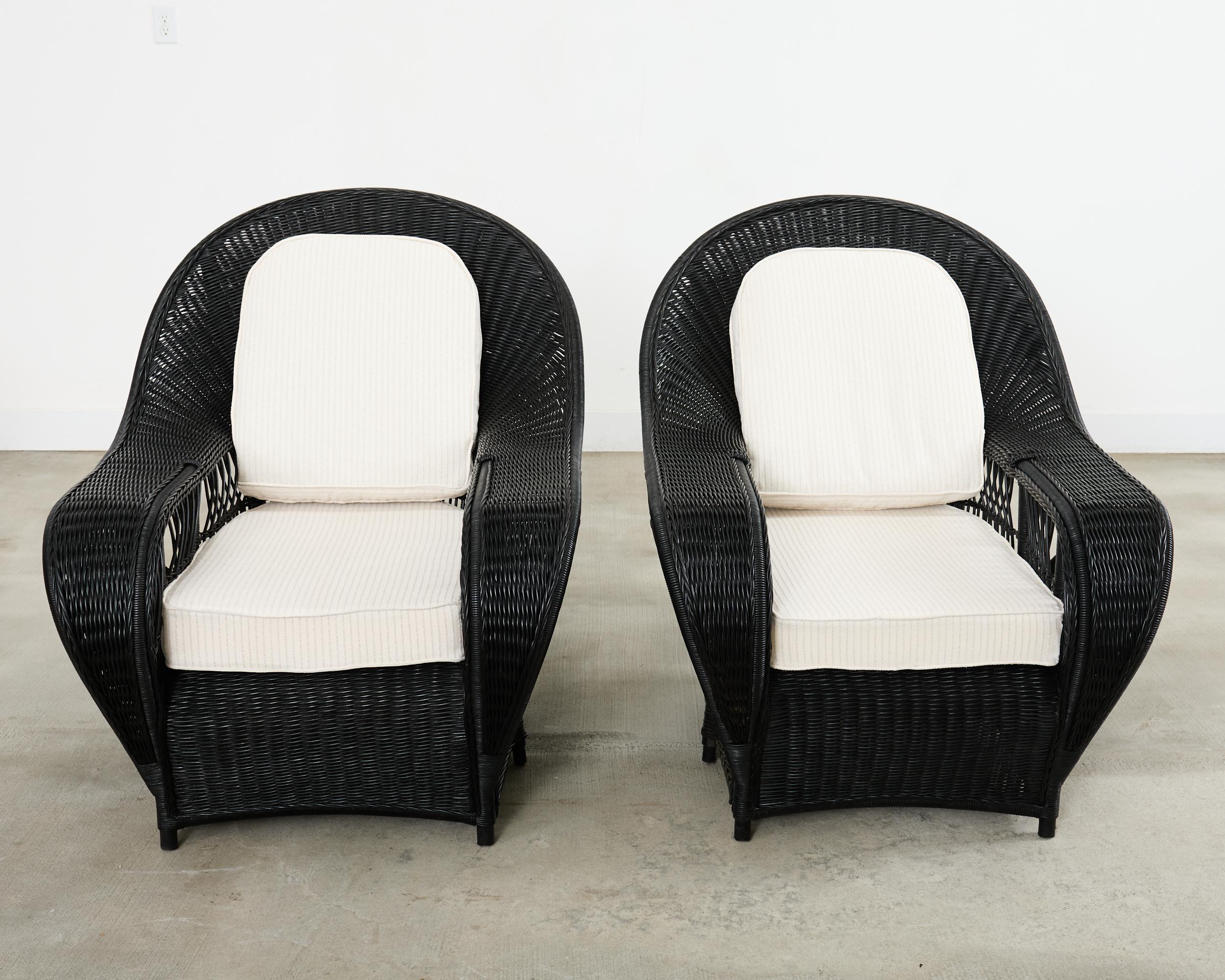 Drammatica coppia di poltrone da giardino in vimini ebanizzato disegnate da Ralph Lauren. Queste rare sedie sono caratterizzate da una struttura in rattan oversize impreziosita da un intreccio di vimini. Le cornici graziosamente curvate hanno spessi