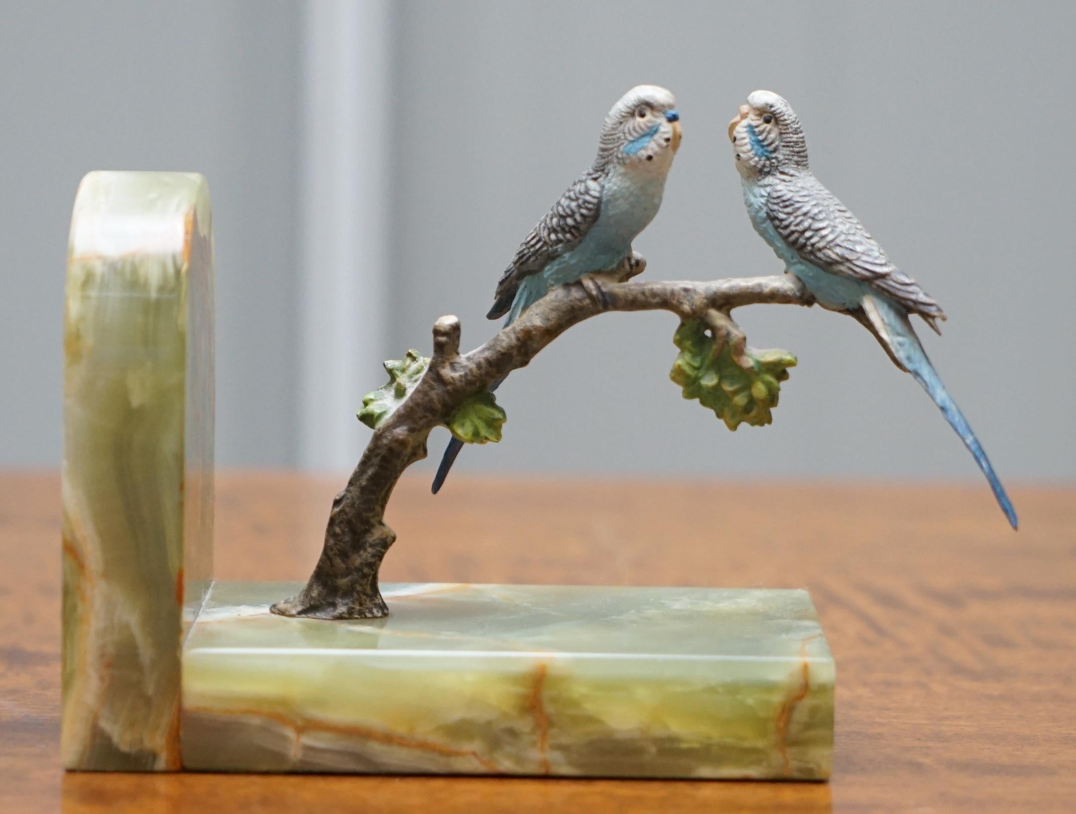 We are delighted to offer for sale this stunning pair of original circa 1920 Austrian Vienna cold painted bronze bookends depicting a pair of birds of paradise budgie guards on branches with onyx bases

A truly stunning and exceptionally rare