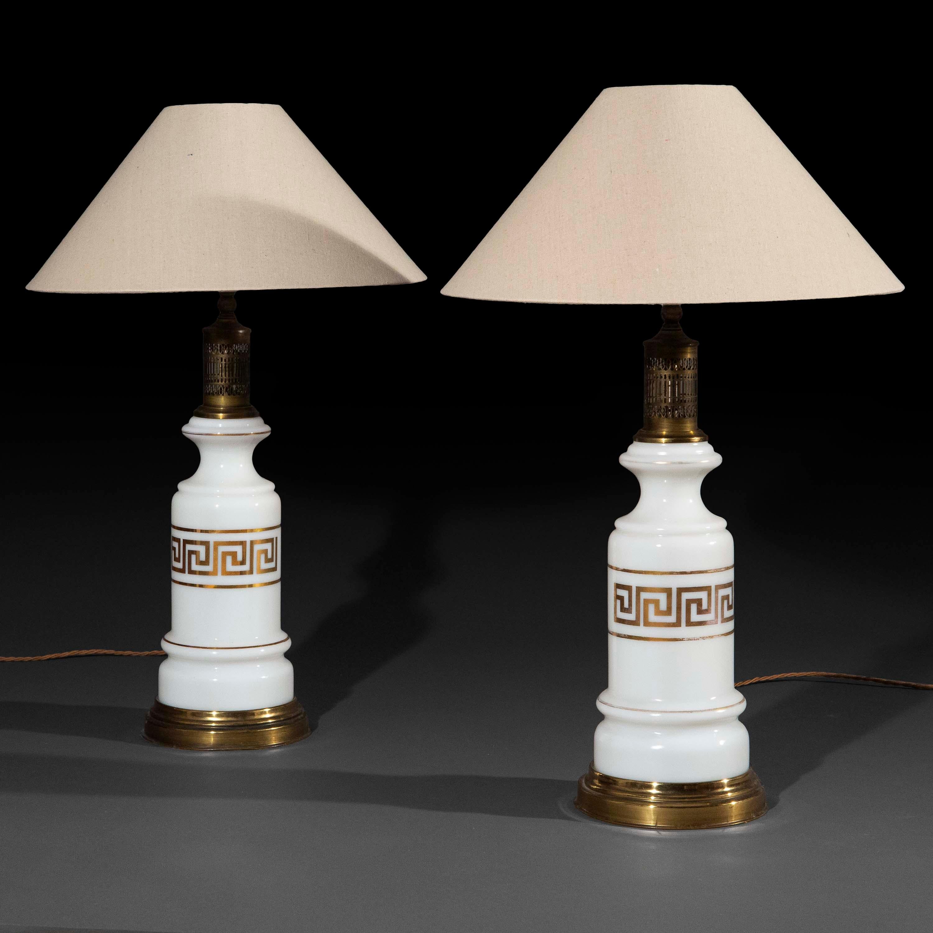 Une paire extrêmement rare de lampes de table merveilleusement élégantes en verre opalin blanc, décorées en doré avec des ornements en forme de clé grecque. Autrefois lampes à huile, aujourd'hui électrifiées.
France, fin 19e - début 20e