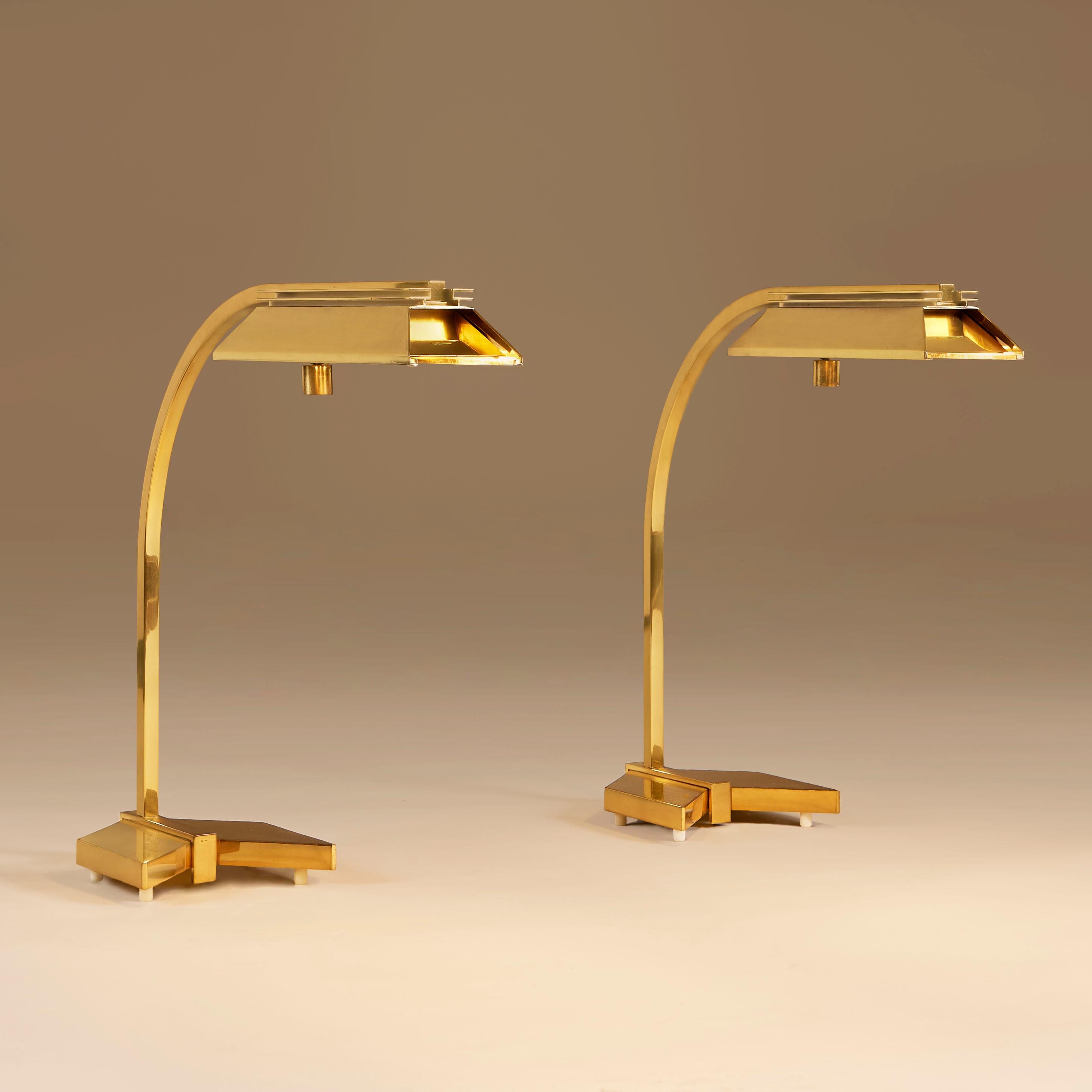 Chic and substantial brushed brass desk lamp with decorative arrow shaped base, curved arm and decorative brass shade.

