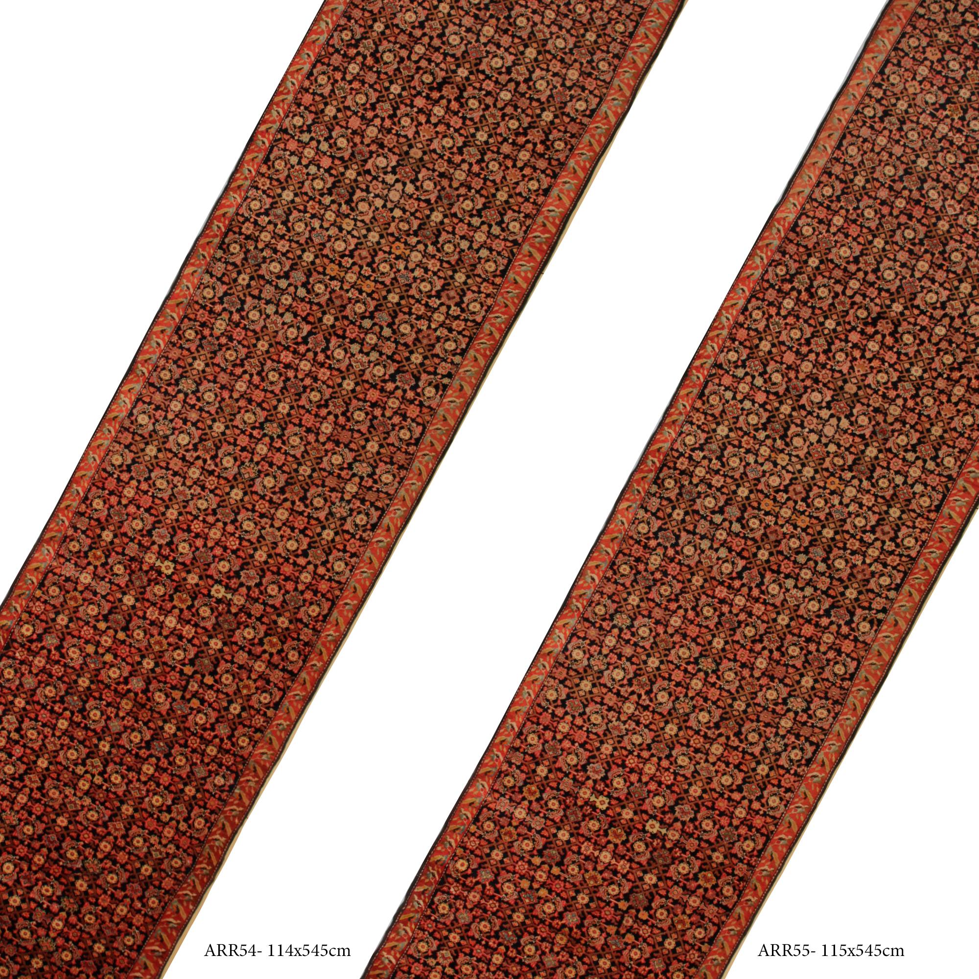 Cette paire unique de tapis anciens a été tissée à la main et présente un fantastique design all-over encadré d'une élégante bordure orange rouille. Le motif central est tissé dans des couleurs orange, crème et marron sur un fond noir contrasté. Le