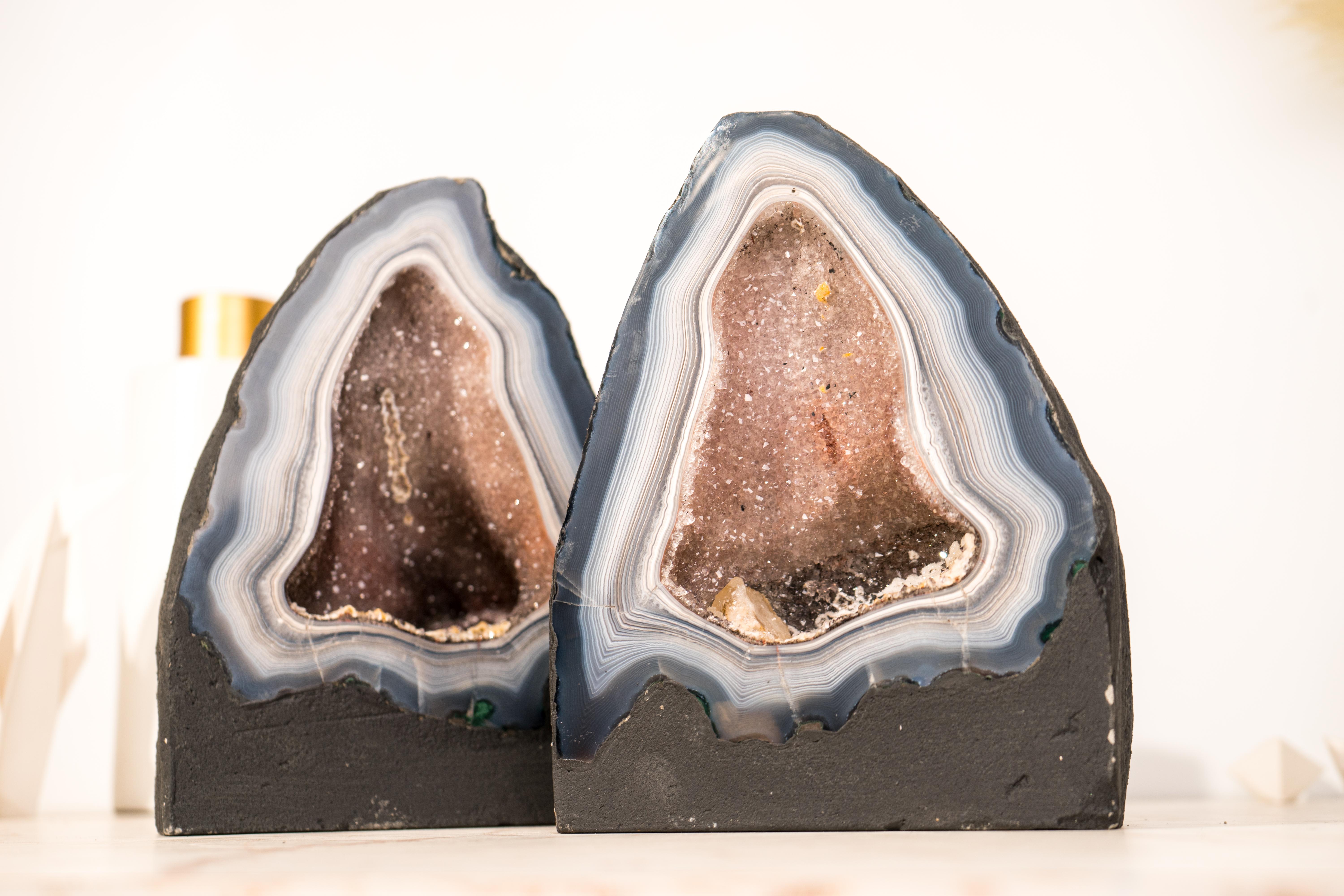 This uniquely rare, large, and beautiful pair of agate geodes will surely elevate your collection or space. Originally one spectacular piece, it has been expertly cut into two matching halves, each showcasing dozens of rarely-seen blue and white