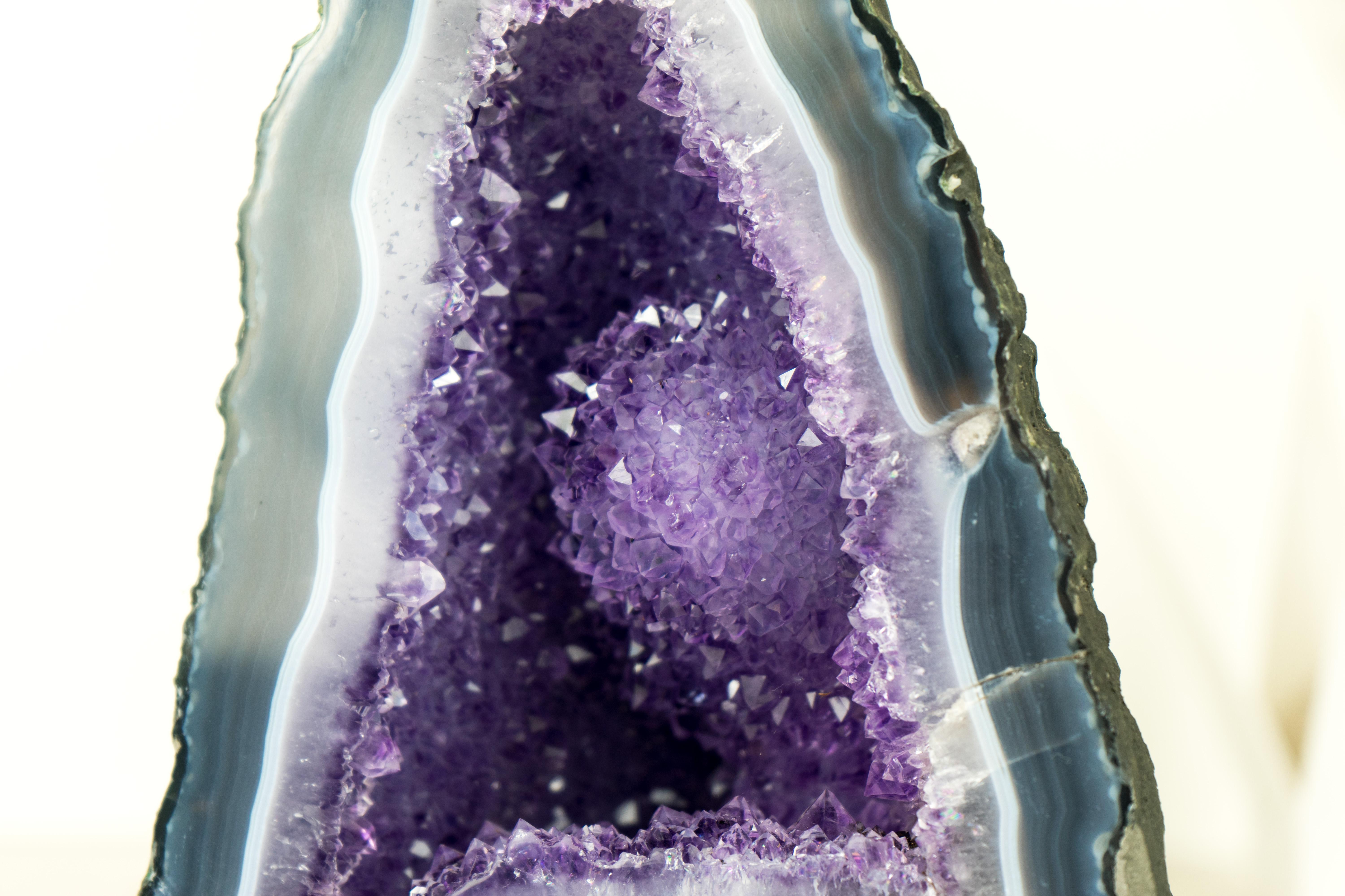 A natural masterpiece, this pair of geodes brings gorgeous Blue and White Lace patterns that form a frame for the gentle Lilac (Rose de France) Amethyst to emerge, crowned by the large Amethyst Rosette blooming from within. A piece of natural