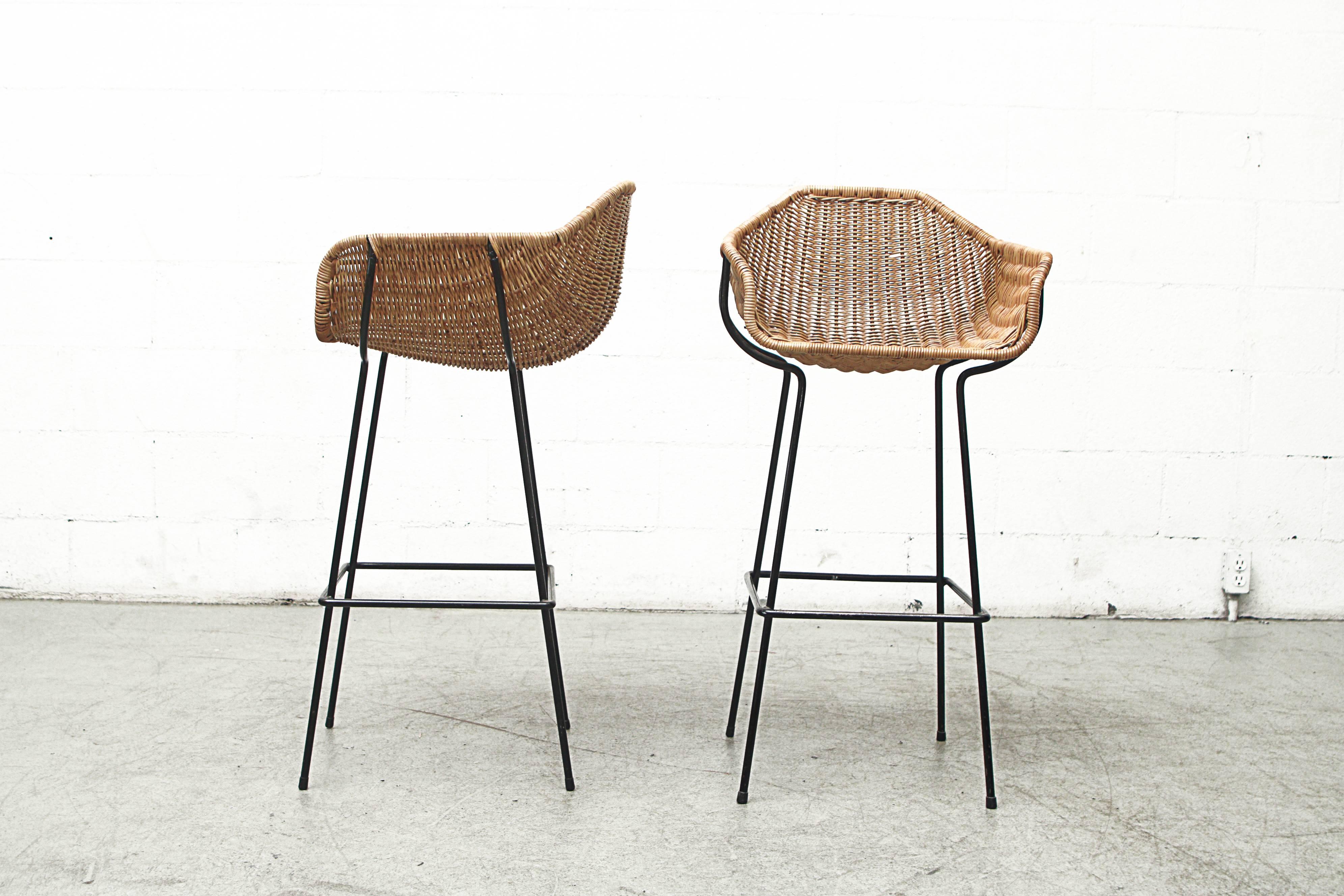 Gorgeous pair of original bar stools with woven rattan bucket seats and black enameled metal frames. Original condition with visible signs of wear consistent with its age and usage. Set price.
