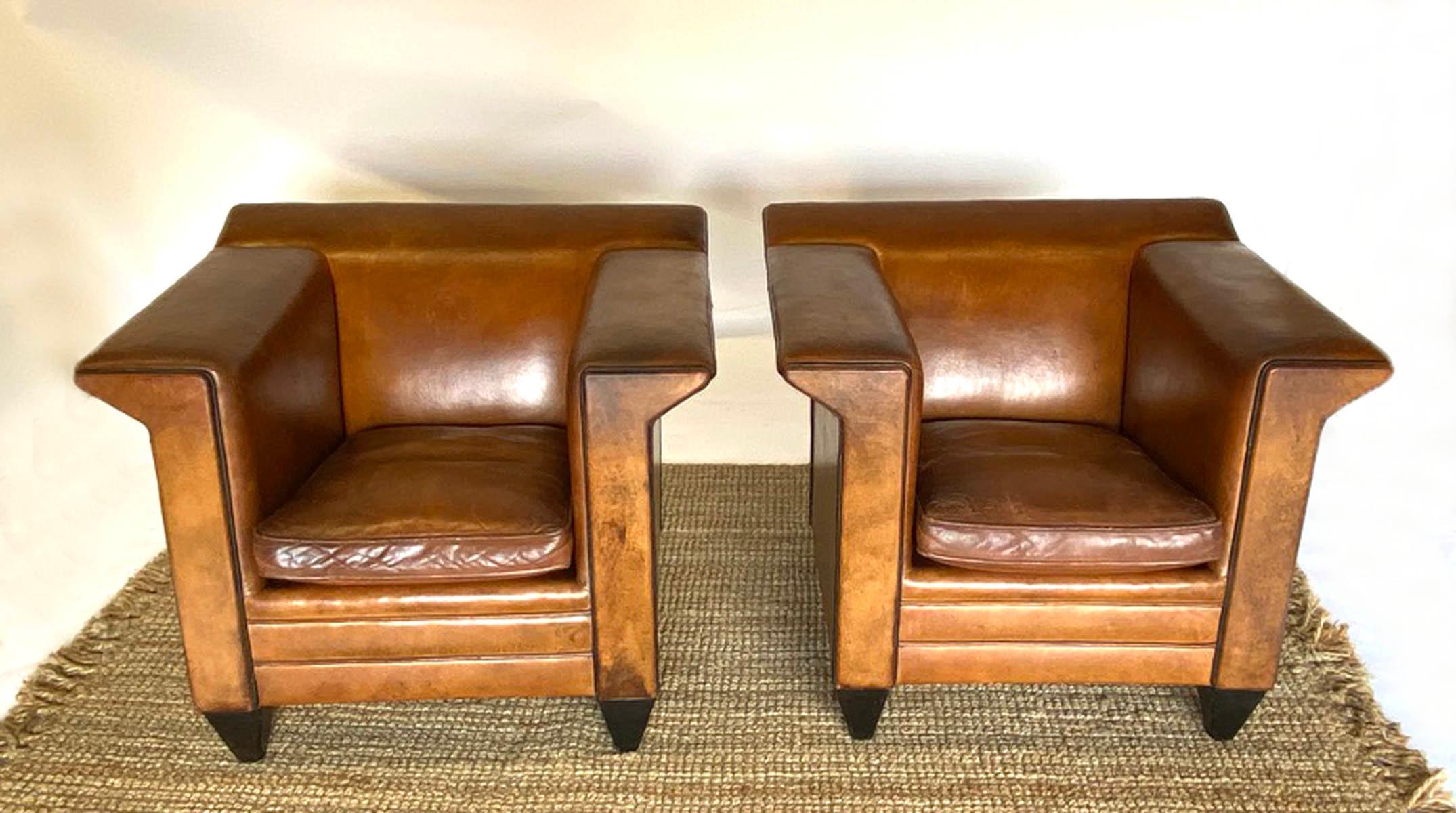Exceptional tobacco leather armchairs by Bart Van Bekhoven. Angular, modern design, piped with black leather accentuates the angular shape. Four legs are also covered in black leather. These chairs have been refurbished, not losing their original