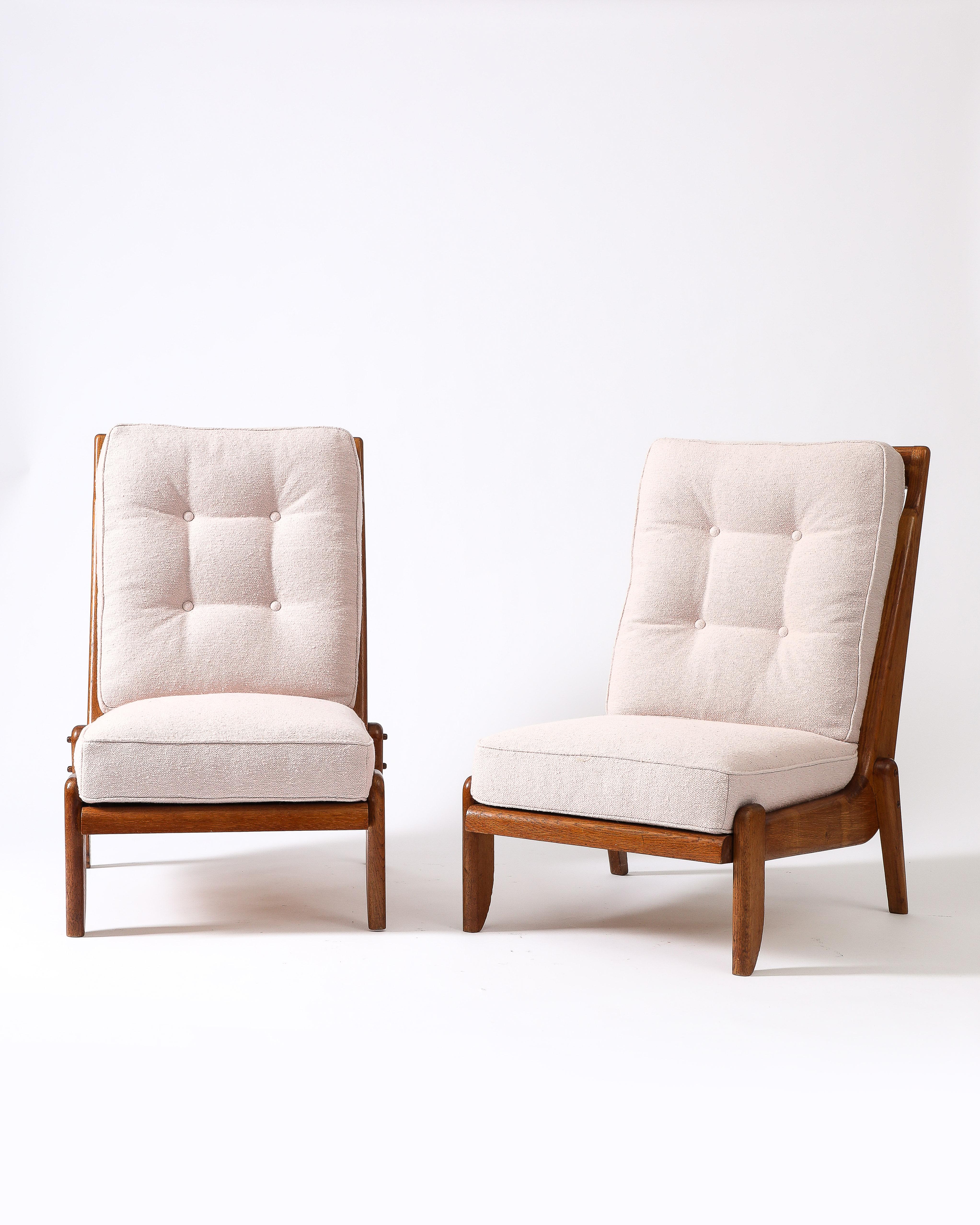 Two available, sold as a pair.

These low lounge chairs feature beautifully figured, patinated oak frames with sculpted, thoughtfully joined legs.