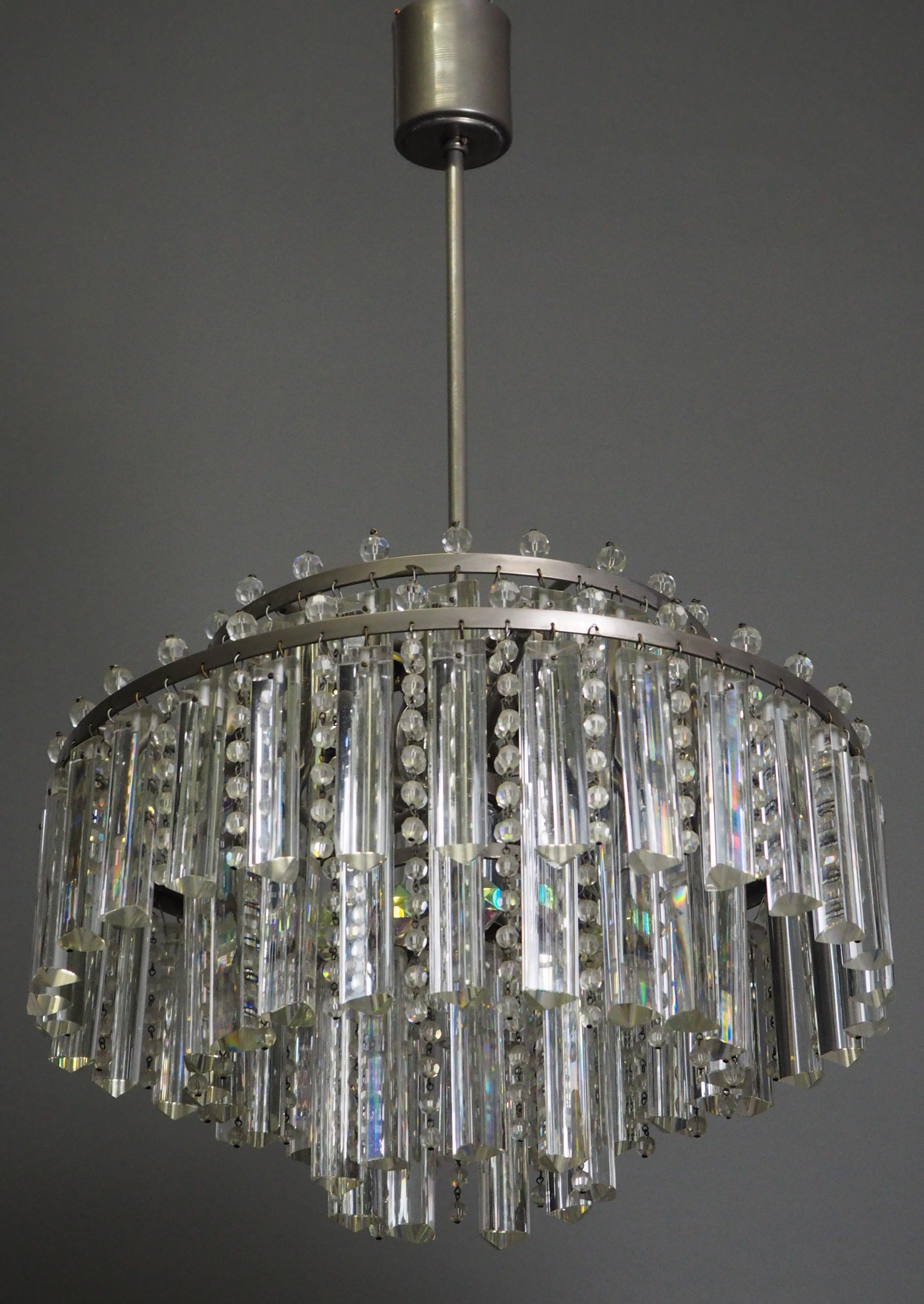 A very rare model of three-tiered six-light glass chandeliers by Palwa, circa 1960s.
The fixtures are made of silver color patinated and heavy triangular glass rods and strass - prism.
Floodlight prisms give this chandelier a striking shape; only