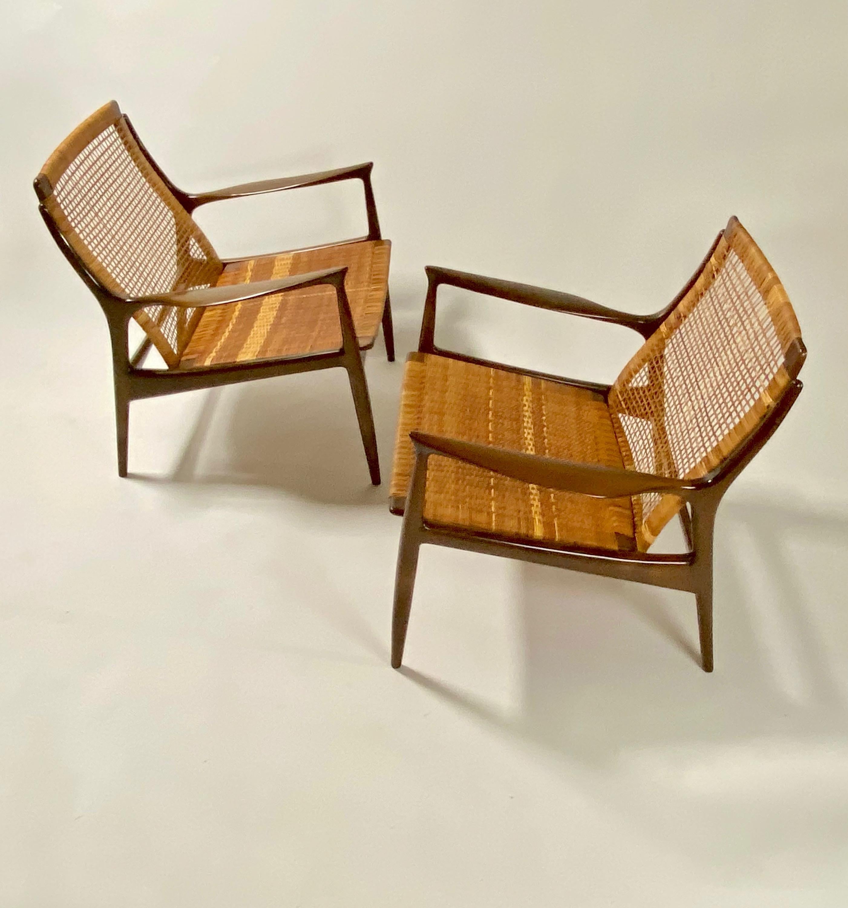 An extremely rare pair of all cane seat and back armchairs designed by Ib Kofod - Larsen for Selig of Denmark, circa 1960s. Sculptural frames i.e. tampered arms, legs and seat backs, give it an impressive presentation. The original finish is a rich