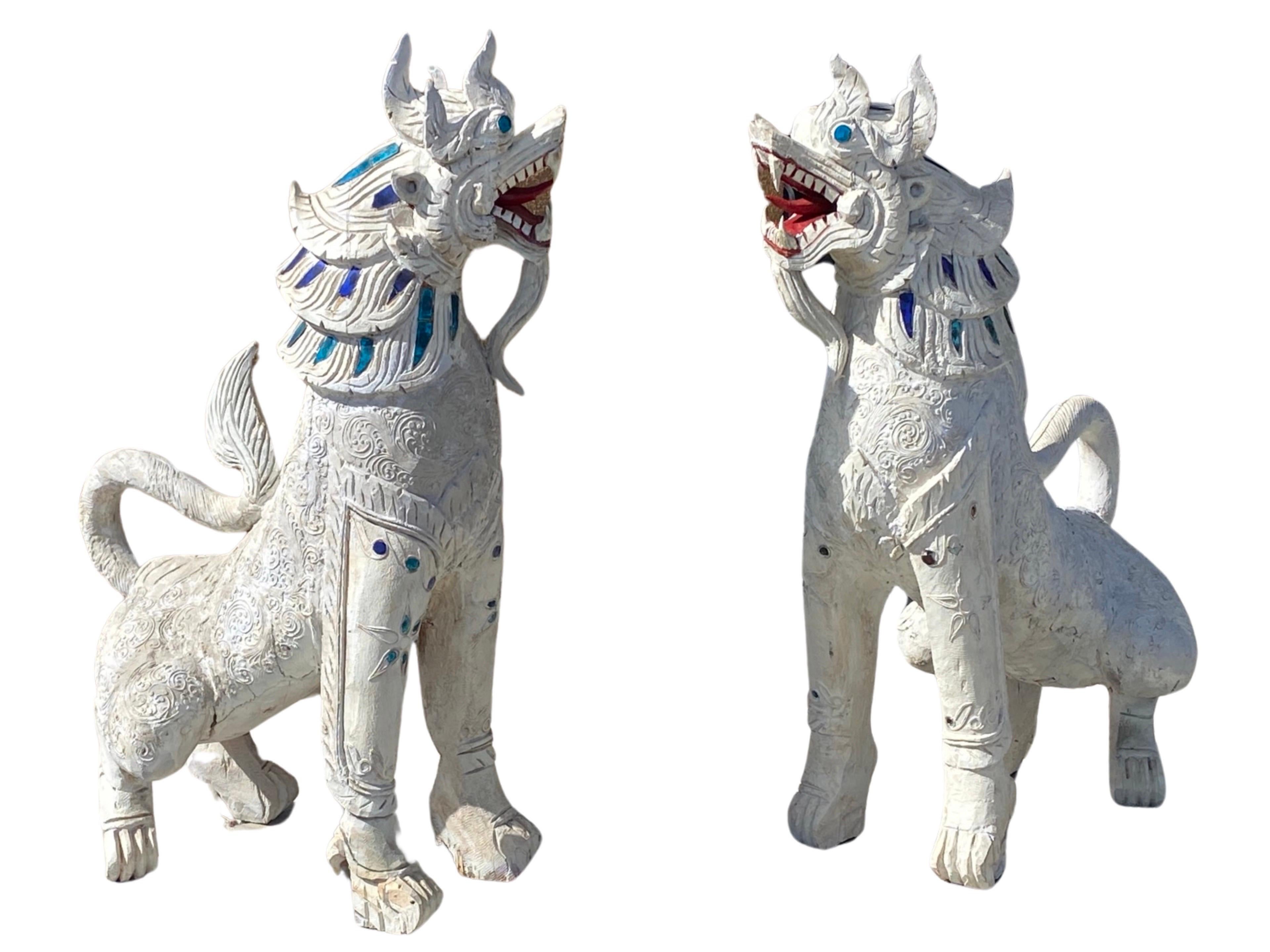 The story of this pair of Thai carved and jeweled wood Singha guardian dogs is as great as the dogs themselves. They were purchased from the estate of a 100 year old wealthy woman that lived in Rancho Mirage, CA. She purchased them in Thailand on