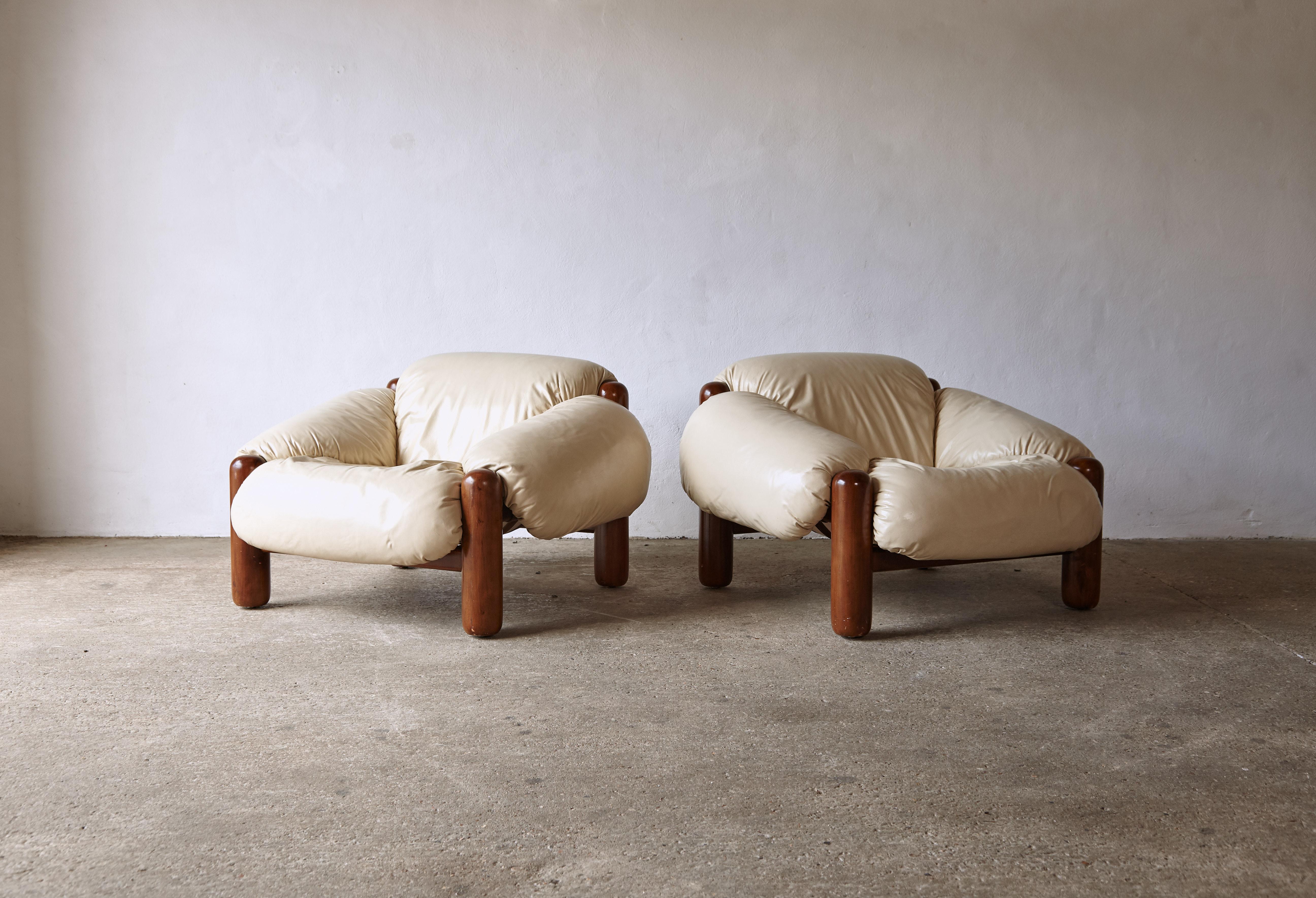 A superb and rarely seen pair of lounge chairs. Made in Italy the chairs nod to Brazilian mid century design. The wooden frames are in original condition, structurally sound, with some signs of use and age. The original cream leather fabric shows