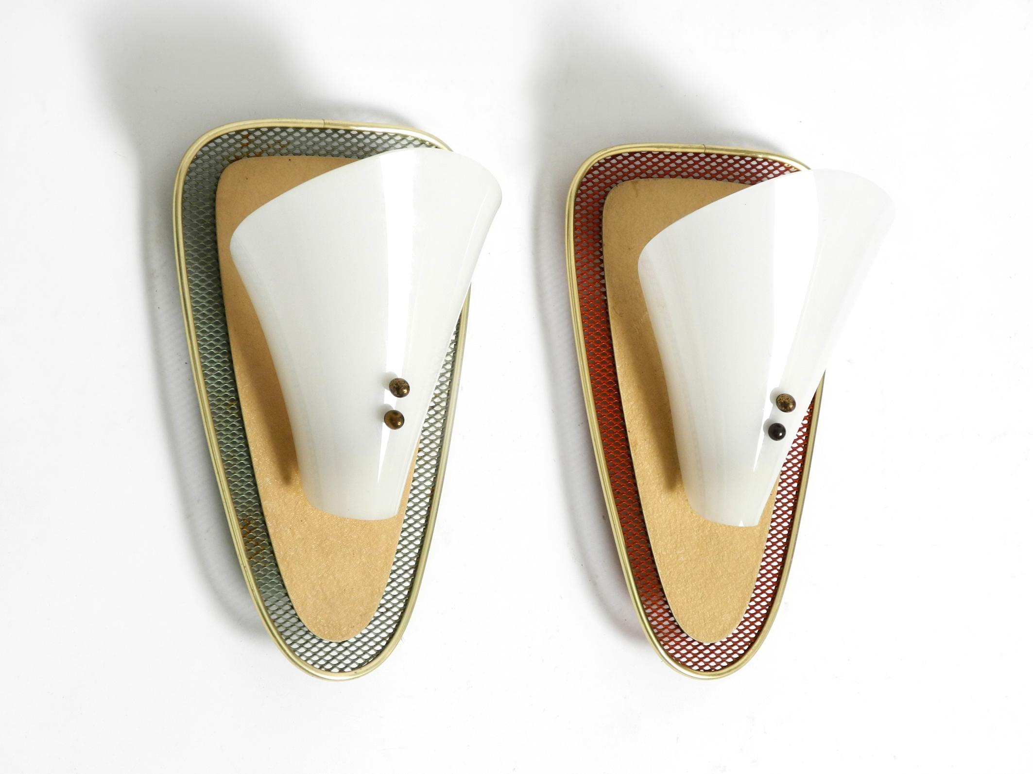 Paar seltene Mid Century Modern Streckmetall-Wandlampen mit Plexiglasschirmen.
Typisch schönes 50er-Jahre-Design. Hochwertig verarbeitet.
Hergestellt aus rotem und grünem Streckmetall und Metallplatte in beigefarbenem Schrumpflack. Der Rand ist aus