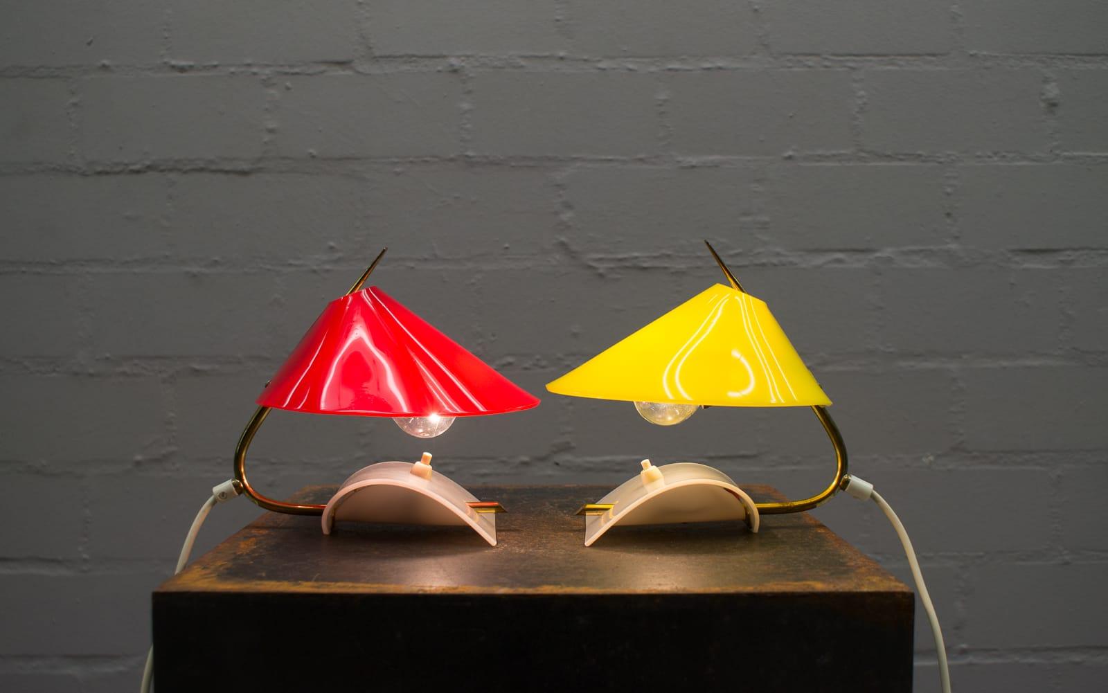 Pair of rare Mid-Century Modern table lamps. 
Lampshades are made of plexiglass one in yellow and one in red. 
Very beautiful 1950s design in good vintage condition. 
100% original condition and fully functional. Makes a fantastically beautiful