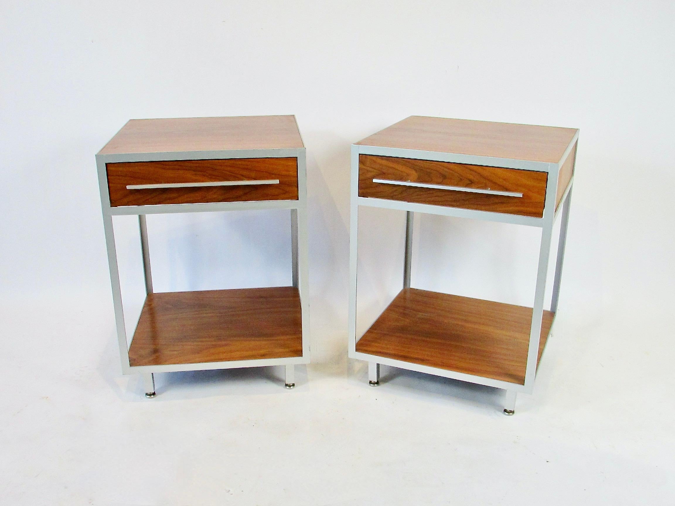 Fine pair of modernist nightstands or side tables . Manufactured by the little known Mueller furniture co. about 1958. Simple minimalist construction . Aluminum frame outlines and supports Walnut top and sides .
Mueller and Slack a Grand Rapids Mi.
