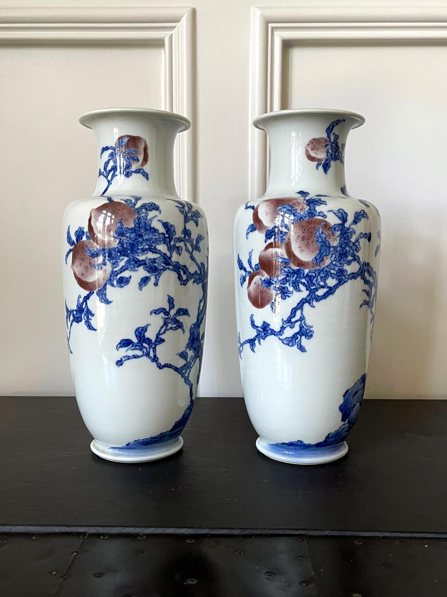 A pair of porcelain vases in classic form, decorated with underglaze blue and copper red painting by Imperial potter Makuzu Kozan. Also known as Miyagawa Kozan (1842–1916), Makuzu was one of the most established and collected ceramist known to the