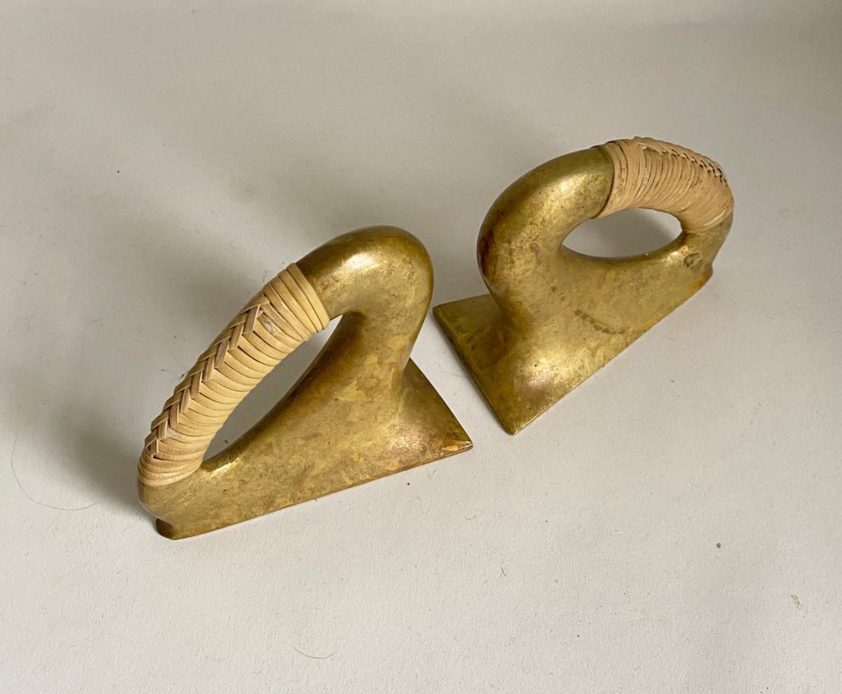 Here is a wonderful pair of rare vintage brass and can bookends by Carl Aubock. The pair is made of heavy brass and wrapped with cane. A very beautiful mix of materials. The bookends are in very good condition. There are no breaks or issues with the