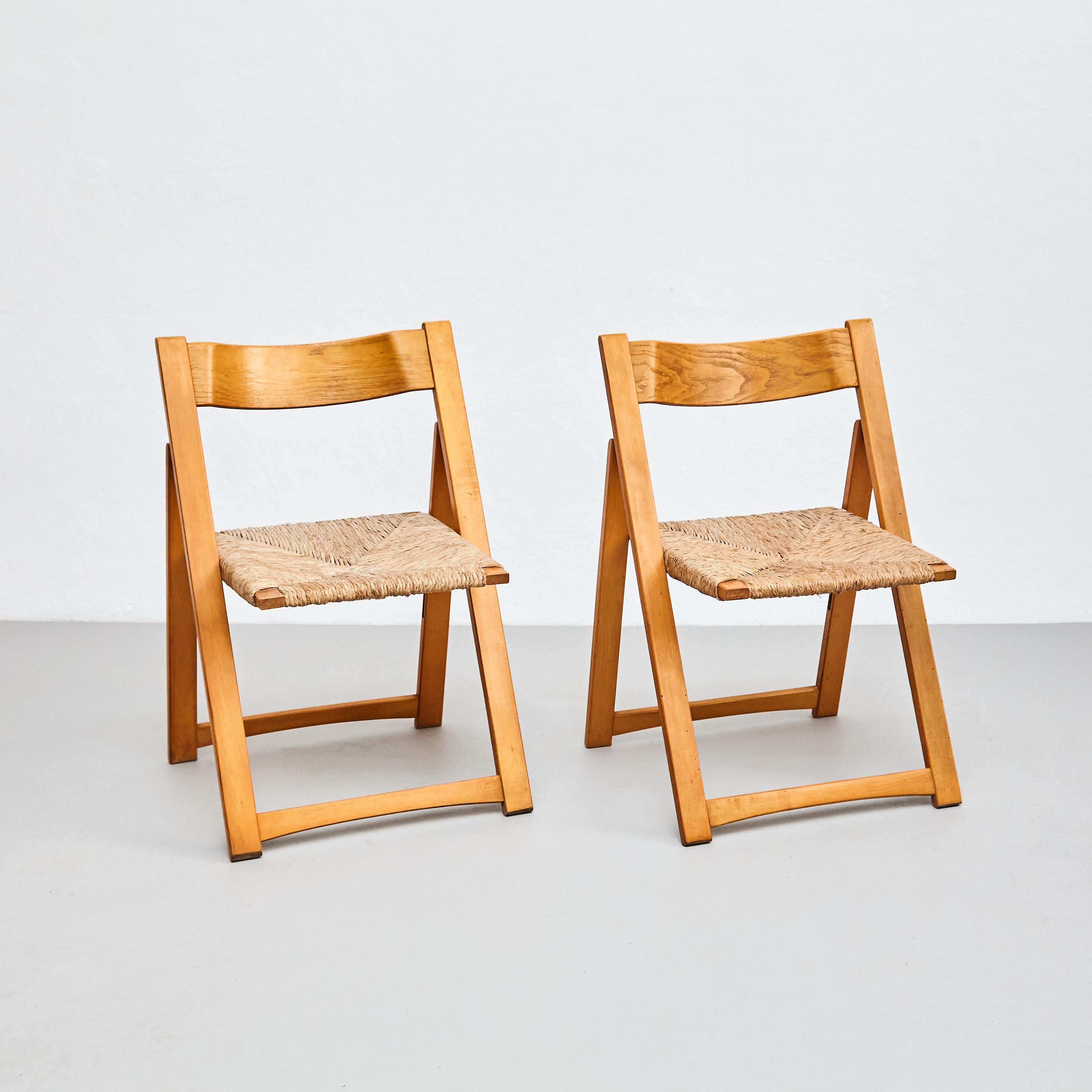 Pair of rationalist rattan and wood folding chairs.

Manufactured in France, circa 1960.

In original condition with minor wear consistent of age and use, preserving a beautiful patina.

Materials: 
Wood, rattan 

Dimensions: 
D 47.2 cm x