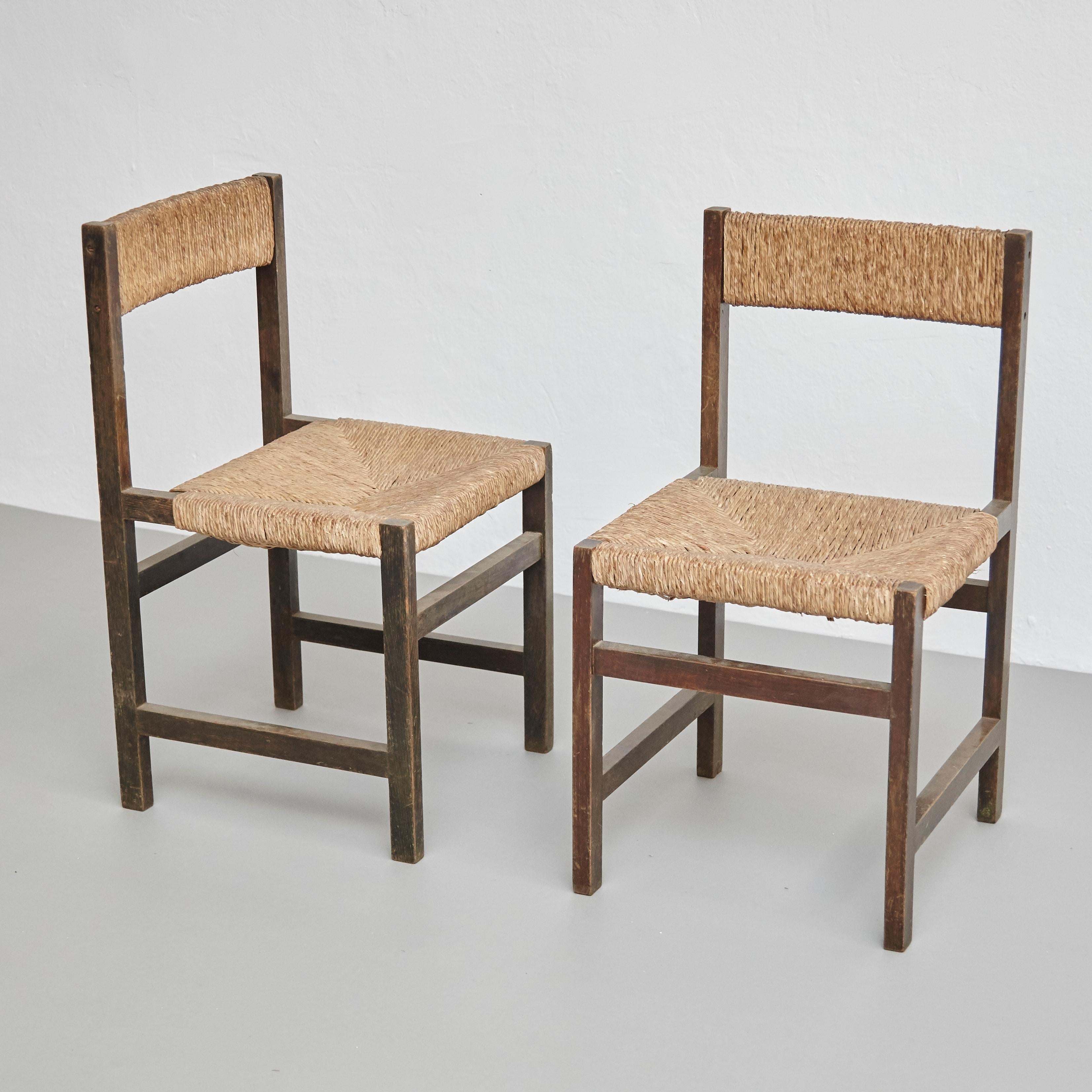 Pair of rationalist chairs.
By unknown manufacturer, Spain, circa 1960.

In good original condition, with minor wear consistent with age and use, preserving a beautiful patina.

Materials:
Wood
Rattan

Dimensions:
D 44 cm x W 42 cm x H 78