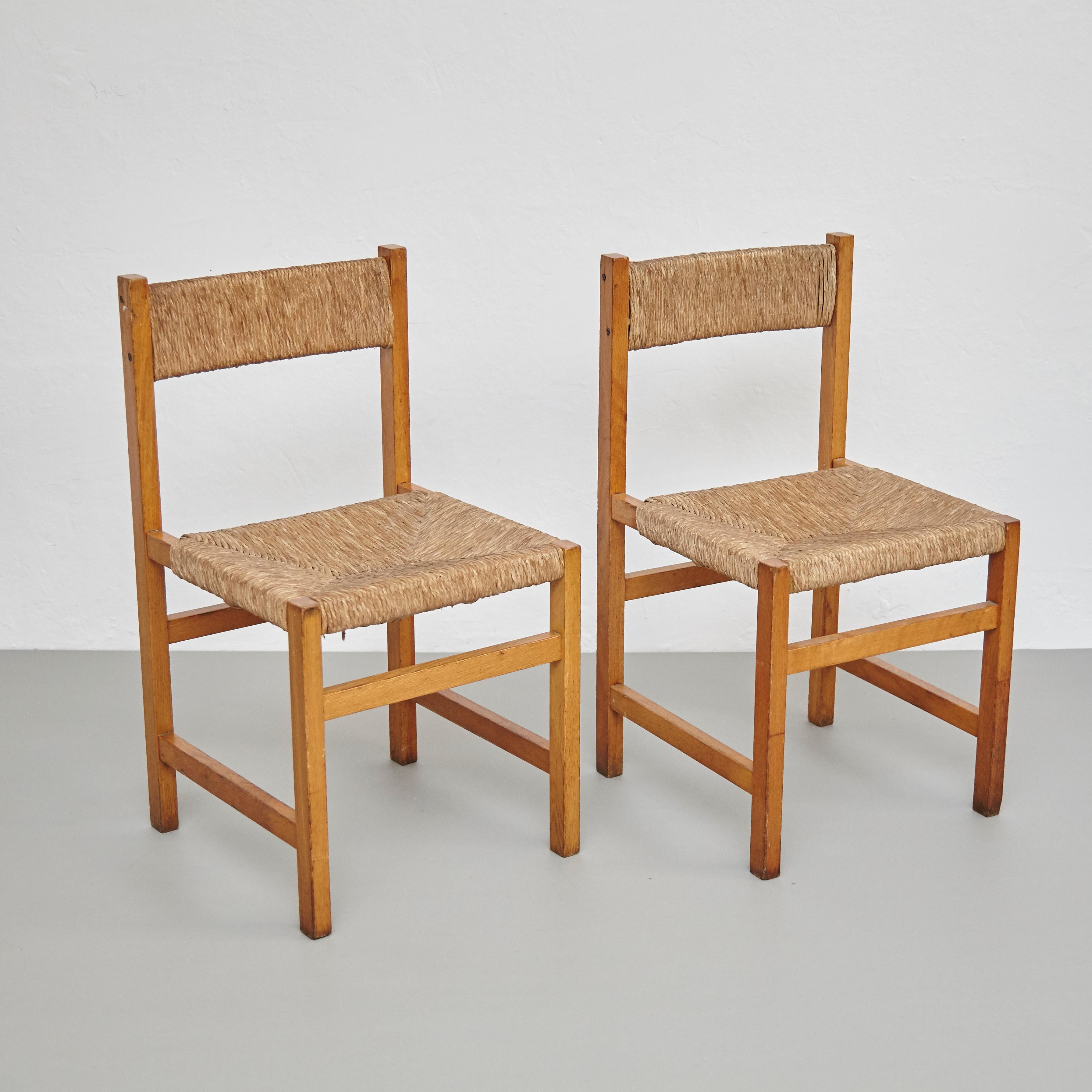 Pair of rationalist chairs.
By unknown manufacturer, Spain, circa 1960.

In good original condition, with minor wear consistent with age and use, preserving a beautiful patina.

Materials:
Wood
Rattan

Dimensions:
D 43.5 cm x W 42 cm x H