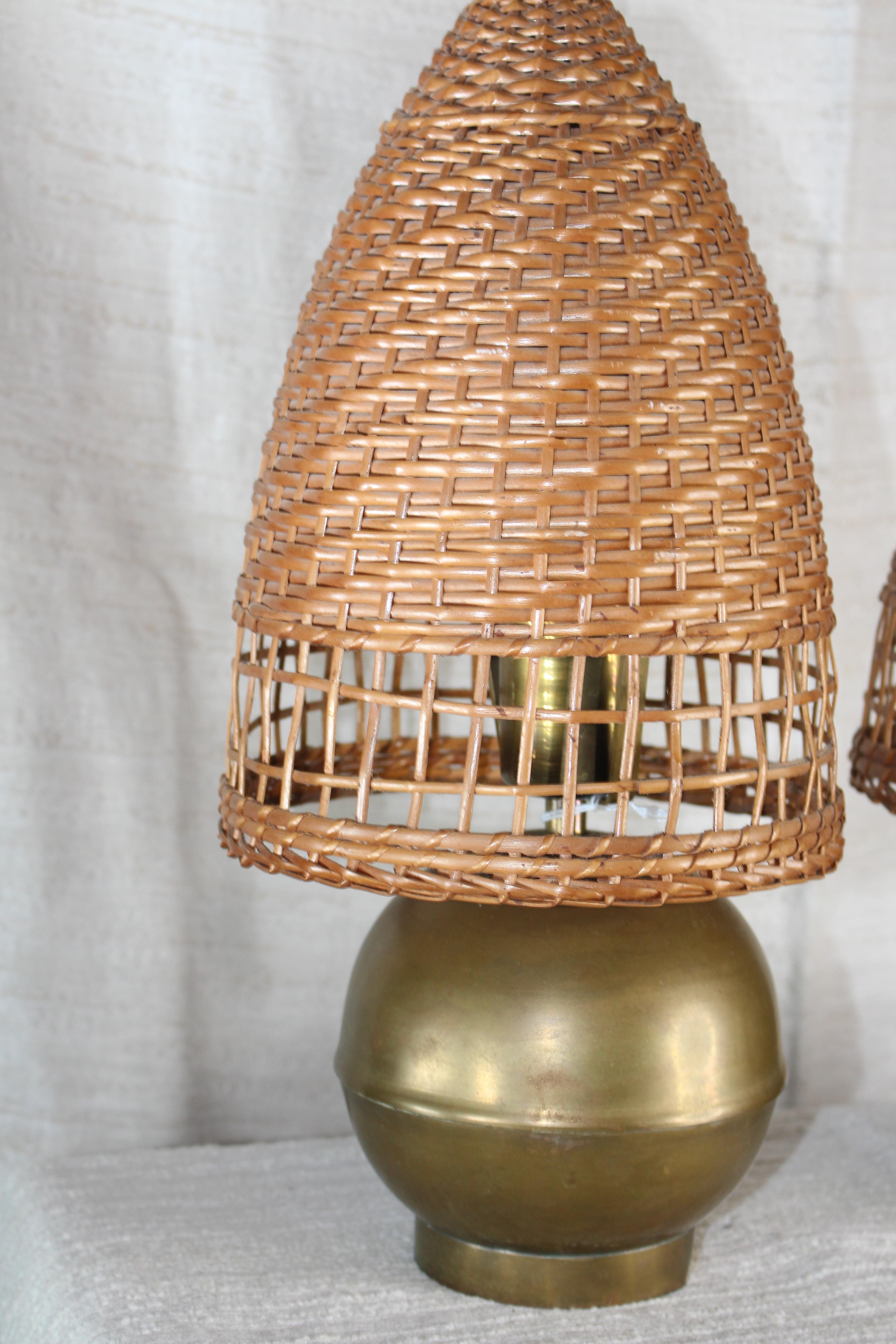 A pair of rattan and brass table or bedside lamps. 

Luminous brass body holding an elegant shade entirely made from Rattan. 


