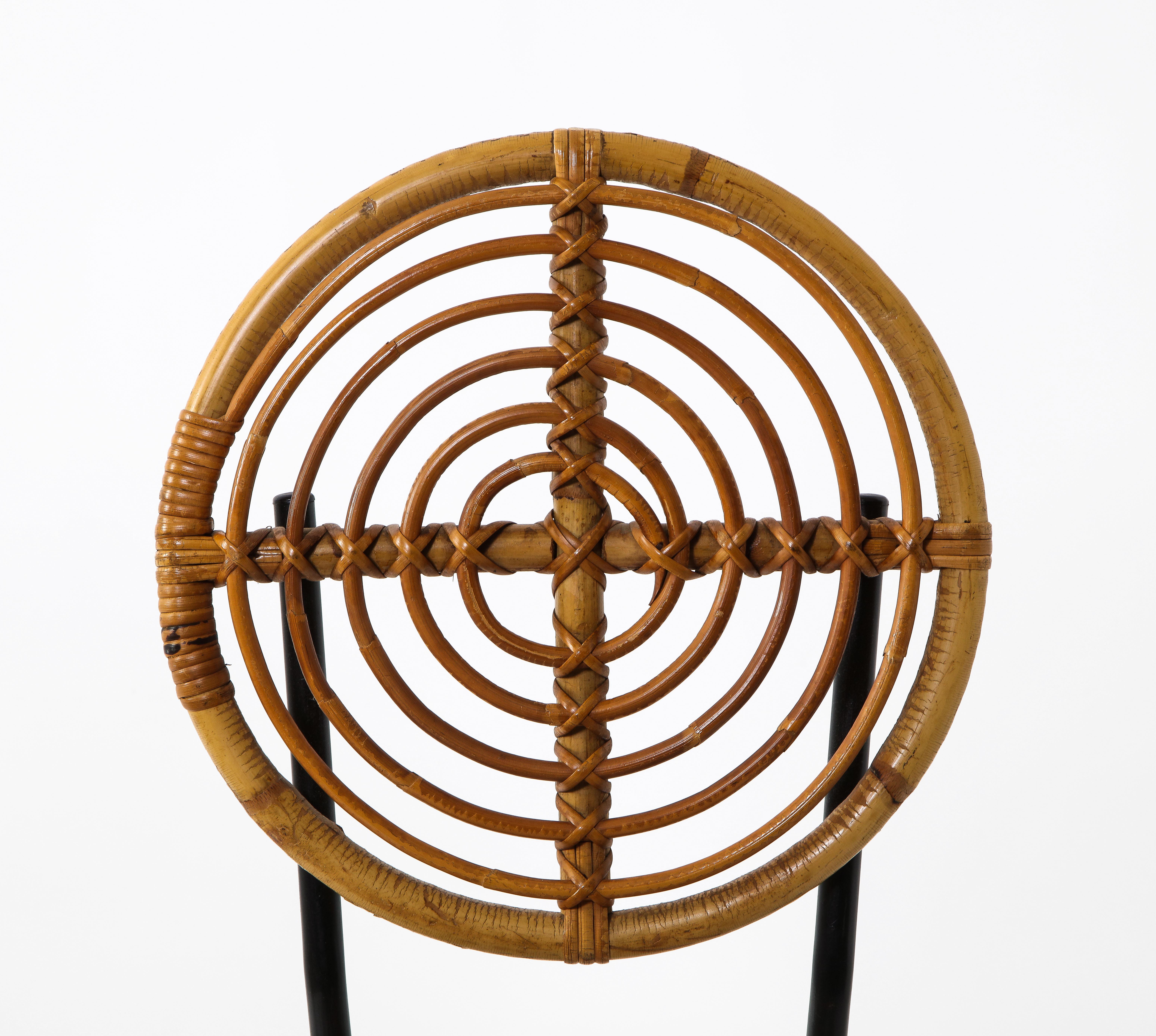 Pair of rattan and painted metal disc chairs, France, 1950s. Disc shaped seats and backs in unique and interesting concentric pattern. Black metal frames. Great sculptural pieces as pull up or side chairs.