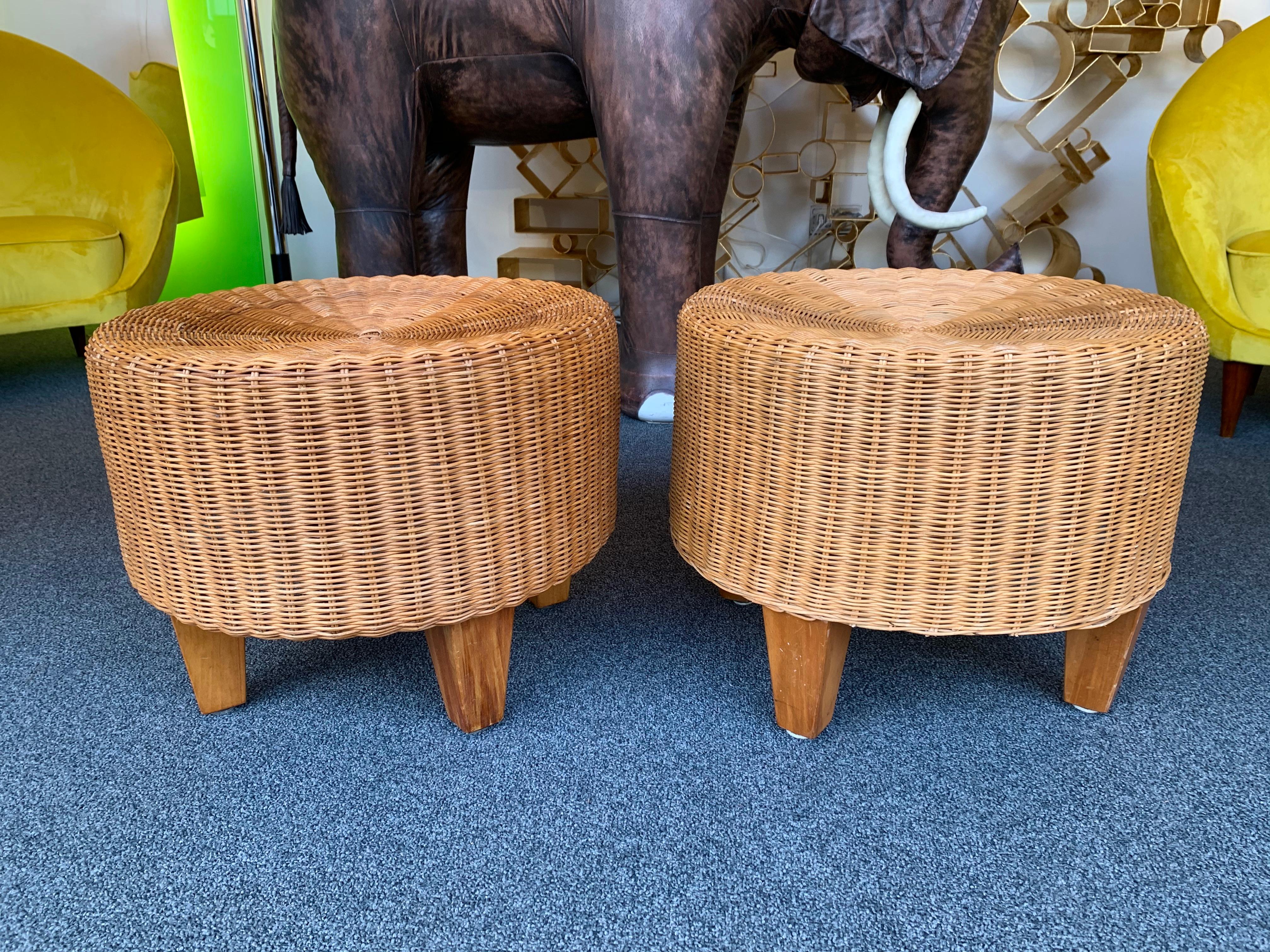 Pair of rattan poufs stools or ottomans with wood feet.