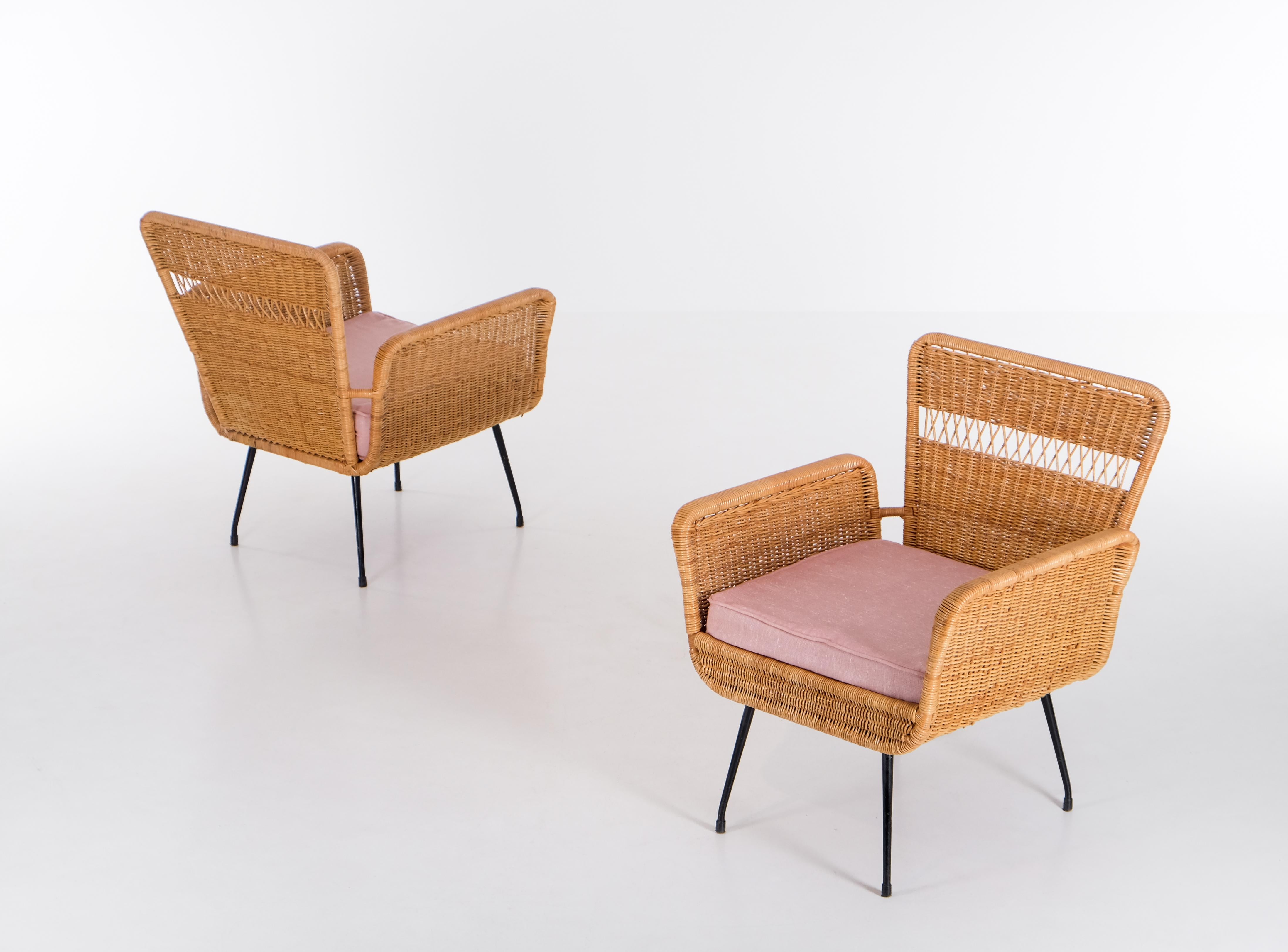 Paire de fauteuils en rotin avec pieds en acier laqué noir. Produit au Brésil, dans les années 1960.
Très bon état avec de petits signes d'utilisation. 
Remarque : table et canapé assortis également disponibles. 