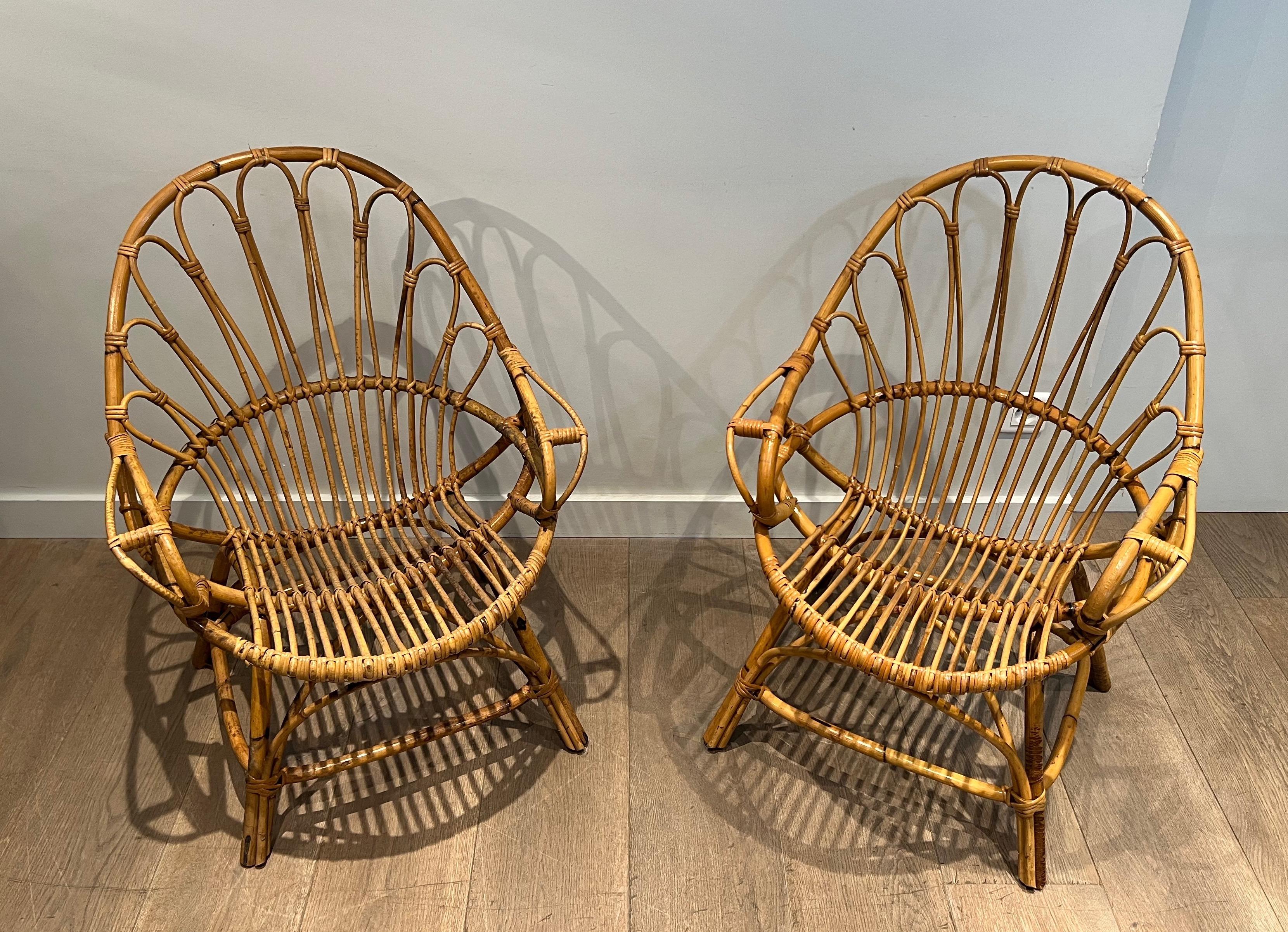 This pair of armchairs is made of rattan. This is a French work, circa 1950.