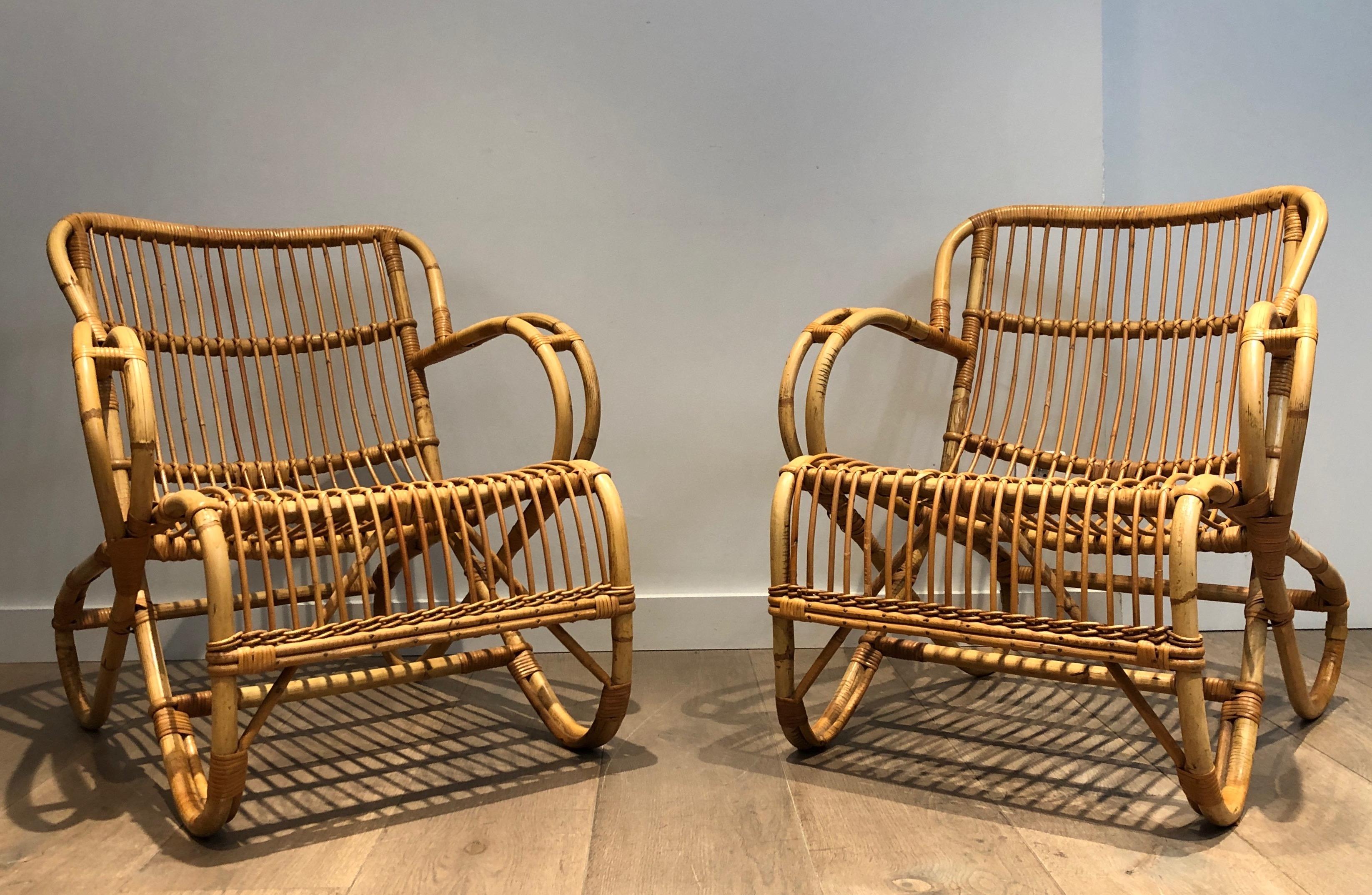 This pair of unusual and design armchairs are all made of rattan. This is a French work. circa 1950.