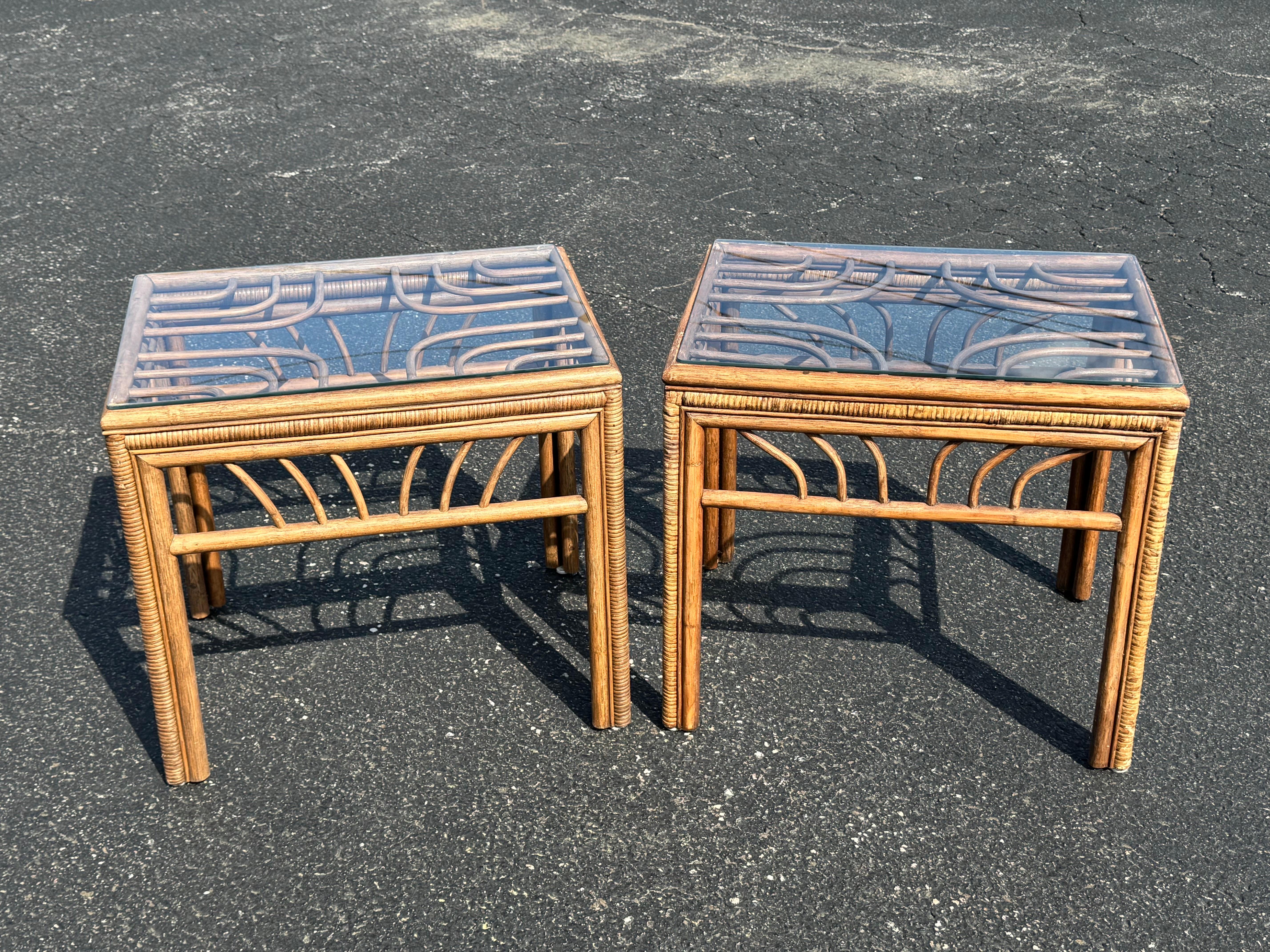 Coppia di tavolini in rattan e bambù con piano in vetro. Bello lo stile decorativo costiero. Il boho chic incontra la spiaggia delle palme. 