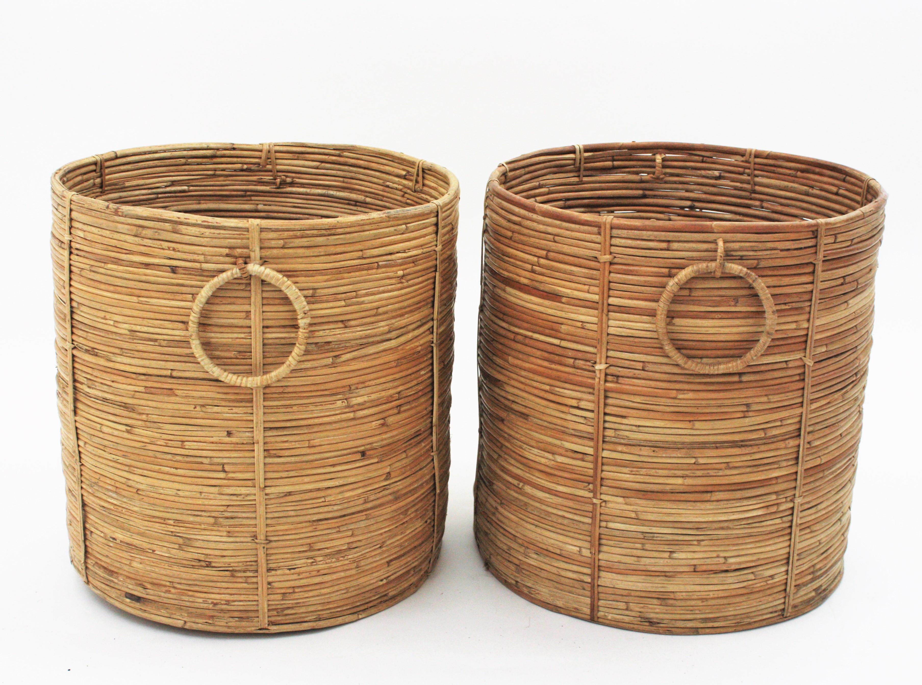 Beautiful Pair of Mid-Century Modern rattan pencil reed large planters or baskets. Handcrafted in Italy, 1970s.
Round shape with ring handles at both sides. Inspired on Gabriella Crespi designs.
Beautiful placed together as a set or at separately