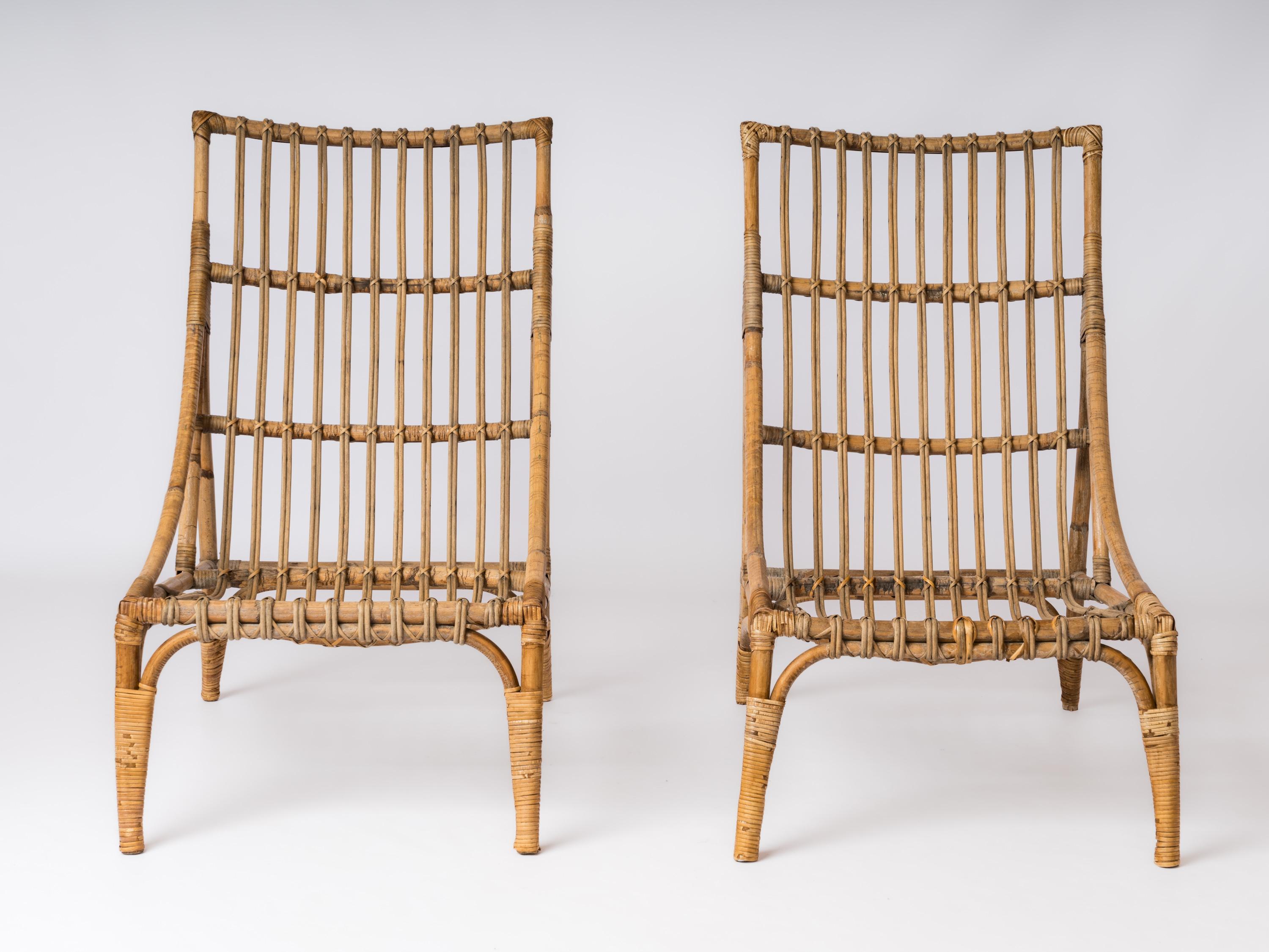 Sleek pair of high back rattan lounge chairs. In the style of Audoux Minnet. 
In fair vintage condition.
Some of the ligatures have been professionally restored.
These chairs will ship from France and can be returned to either France or to an