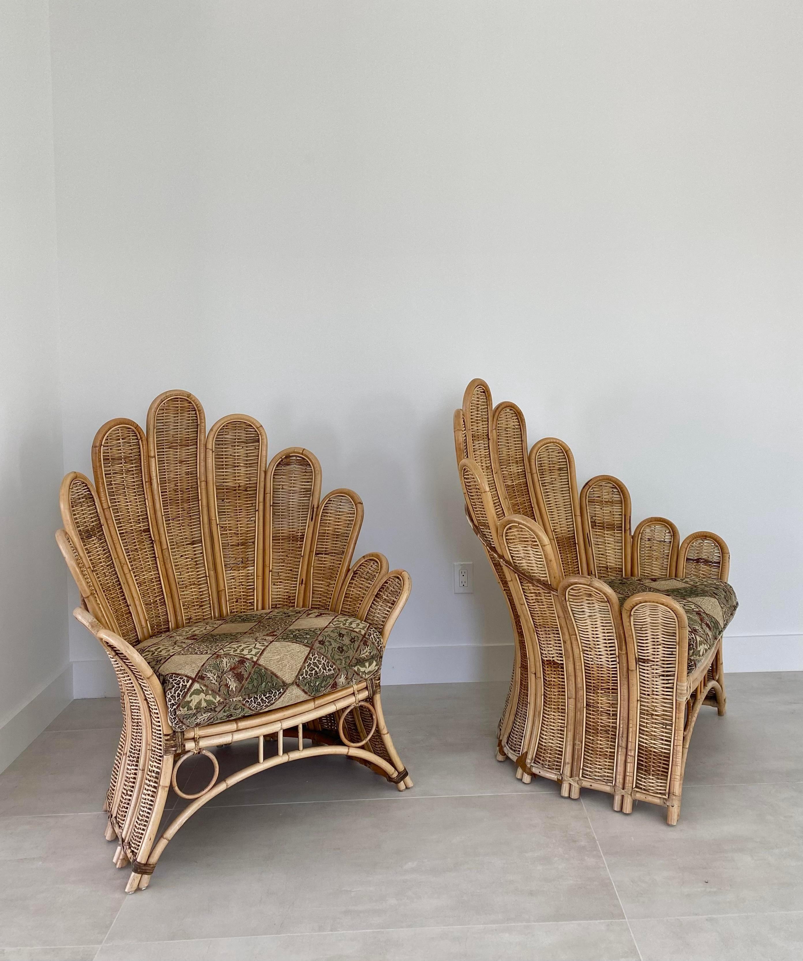 Large-scale palm frond lounge chairs, circa 1980s. Iconic design, in expertly constructed rattan and wicker frames with quality leather binding accents. These chairs are rare to market, especially as a pair, and capture a tropical warm feel and the