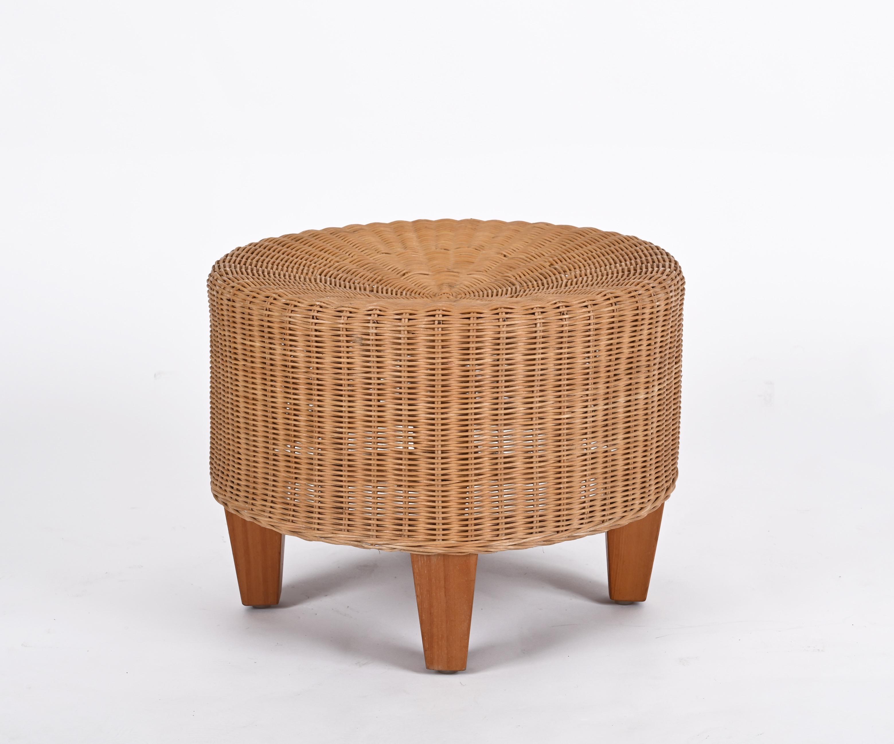 Superbe paire de poufs ronds en rotin tressé à la main et en bois de teck. Ces étonnants ottomans ont été produits en Italie dans les années 1970.

La structure robuste des poufs est en bambou et décorée d'osier tressé à la main. Les quatre pieds