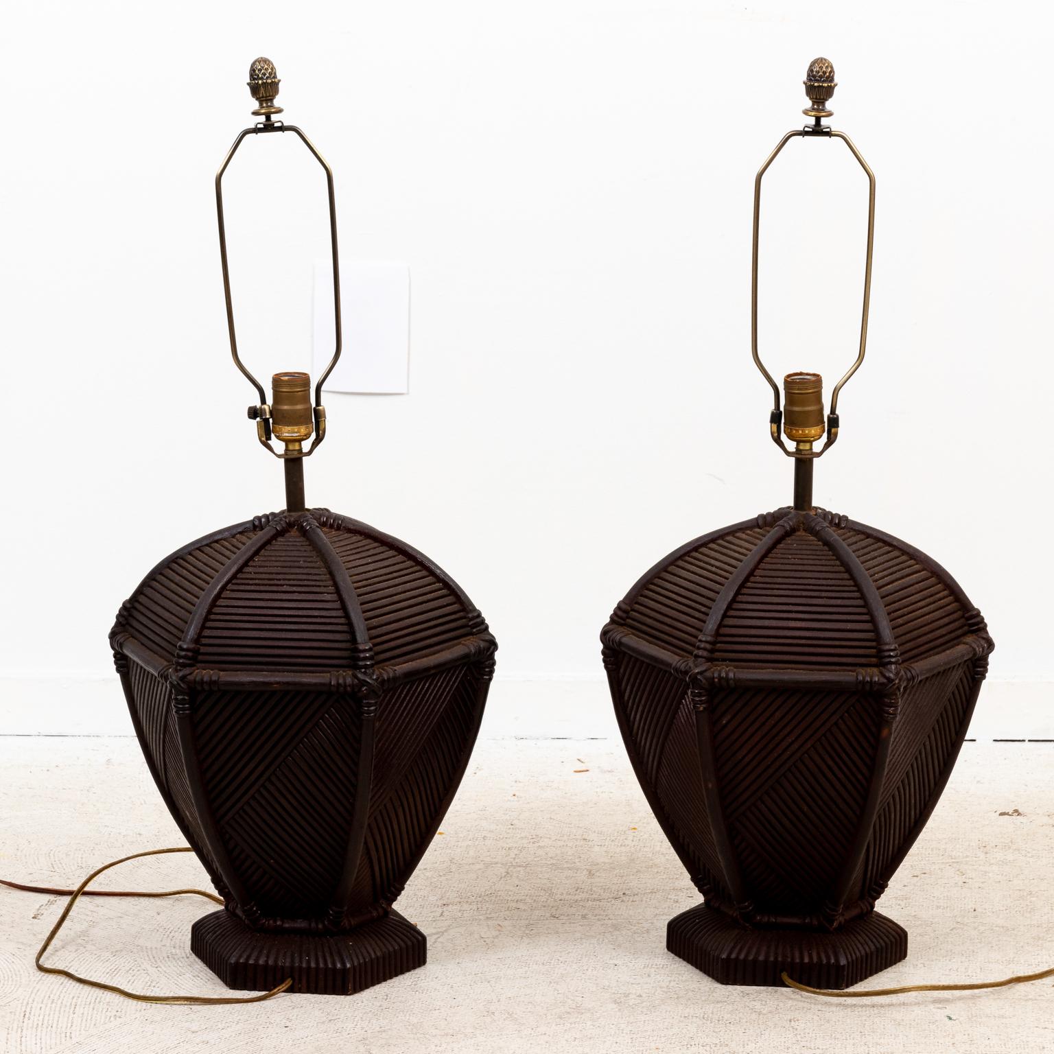 Circa mid-20th century pair of rattan table lamps with ribbed design of hexagonal shapes. The design of contrasting ribbing can be seen on all sides. Weight with electrical hardware. Please note of wear consistent with age. Shades not included.