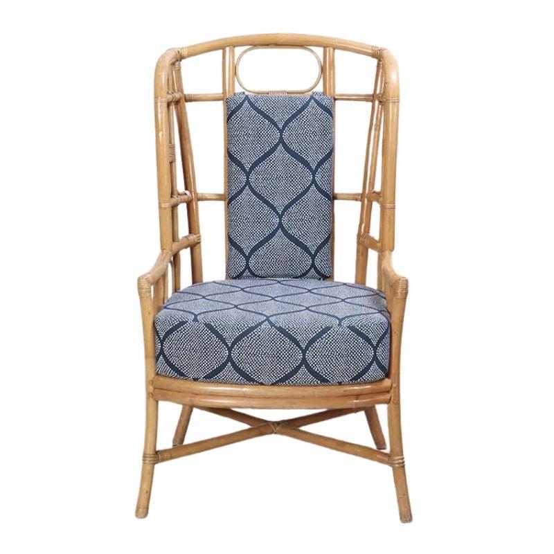 A pair of rattan wingback chairs with a geometric trellis blue and white fabric seat and back cushion. The natural finish of the rattan adds warmth and texture, creating a welcoming atmosphere in any space. The wingback silhouette not only exudes