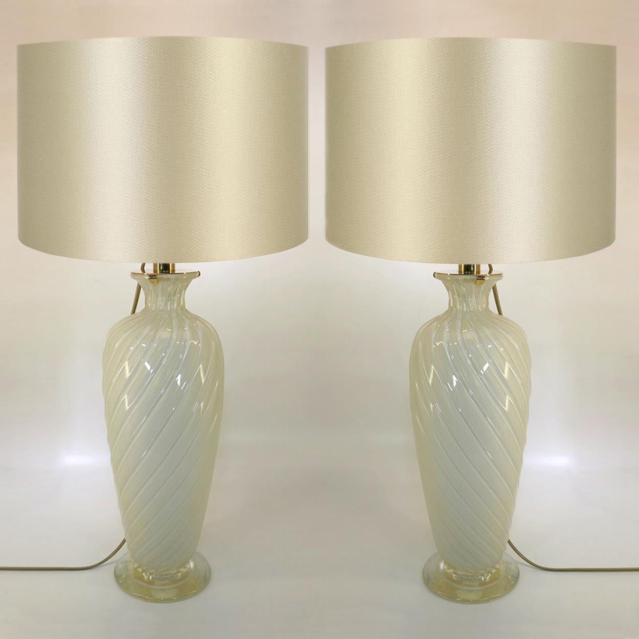 Beautiful pair of lamps. Clear glass inside white underlay with fine gold dust inlay. With light gold colored lamp shades.
Design: Marina Ravagnan Gabbiani.
Measures: Height glass 15.7