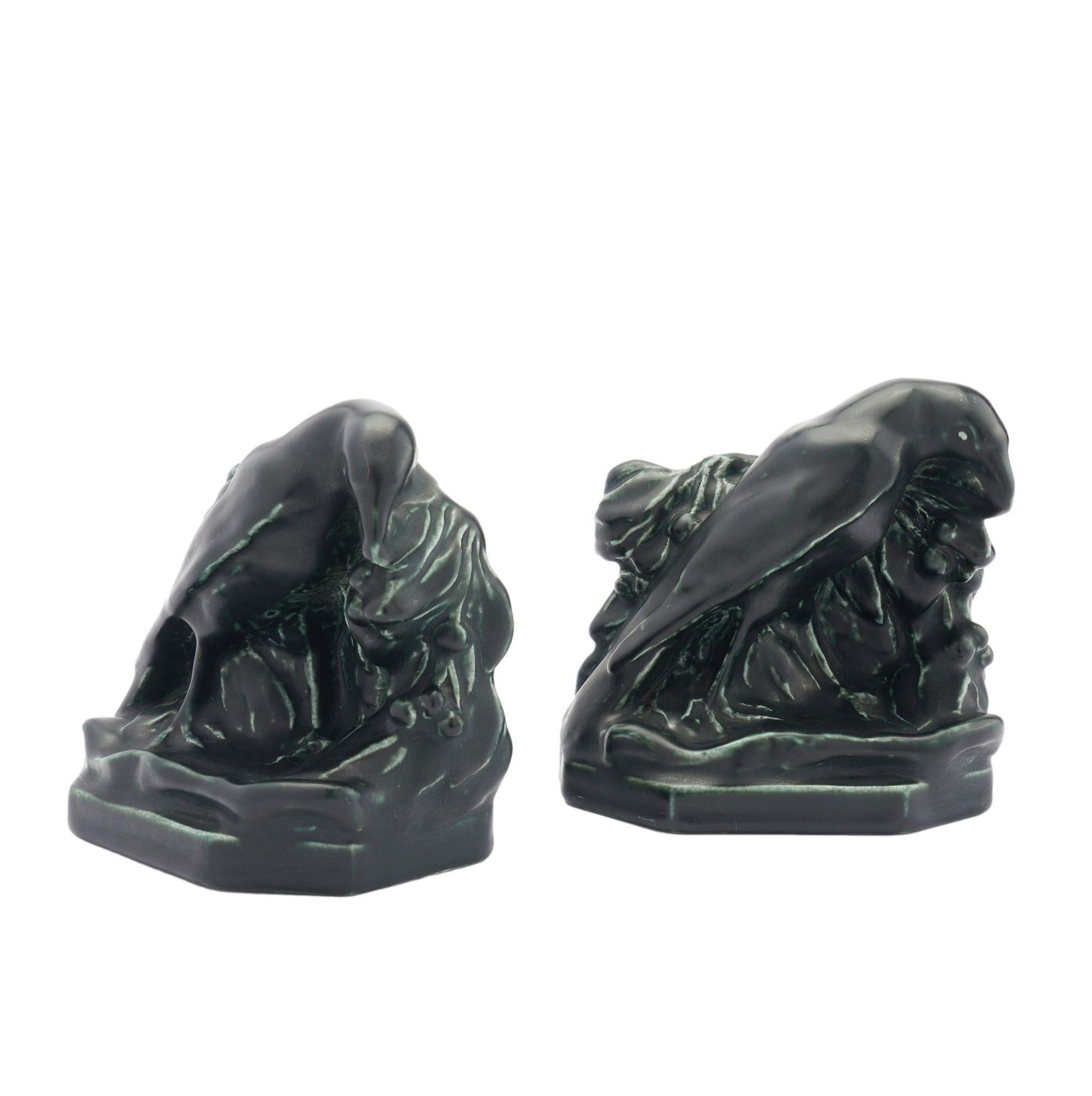 Pair of matte black glazed ceramic bookends of a raven surrounded by leaves. Designed by William Purcell McDonald.
Stamped on the underside: XXIX, 2275

Cincinnati, Ohio, 1929.