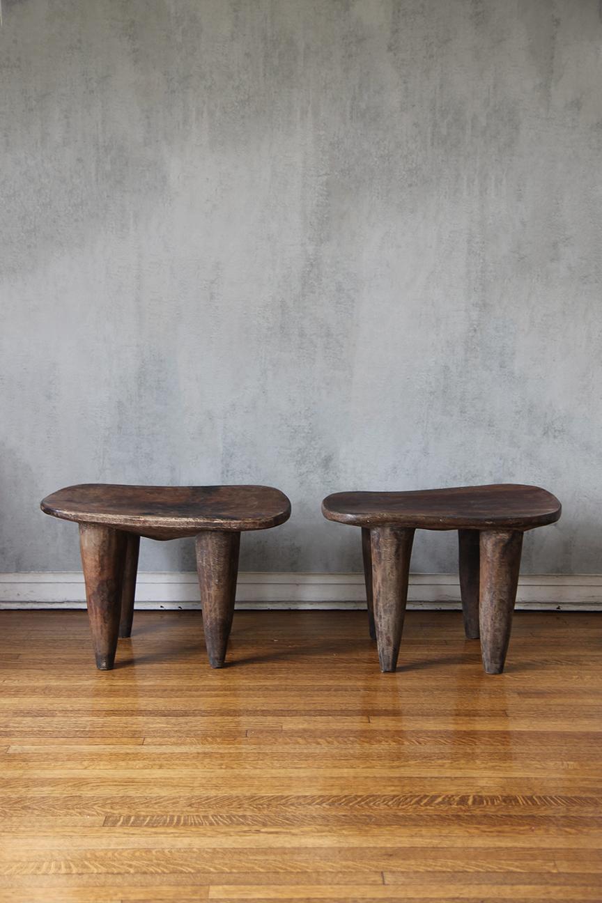 Rare !! Almost identical size !!! African Senufo side Tables on four tapered legs with an abstract form. 
Abstract and geometric patterns integrated in their design, heavy shaped legs Carved from one piece of wood.
Senufo designs are popular for