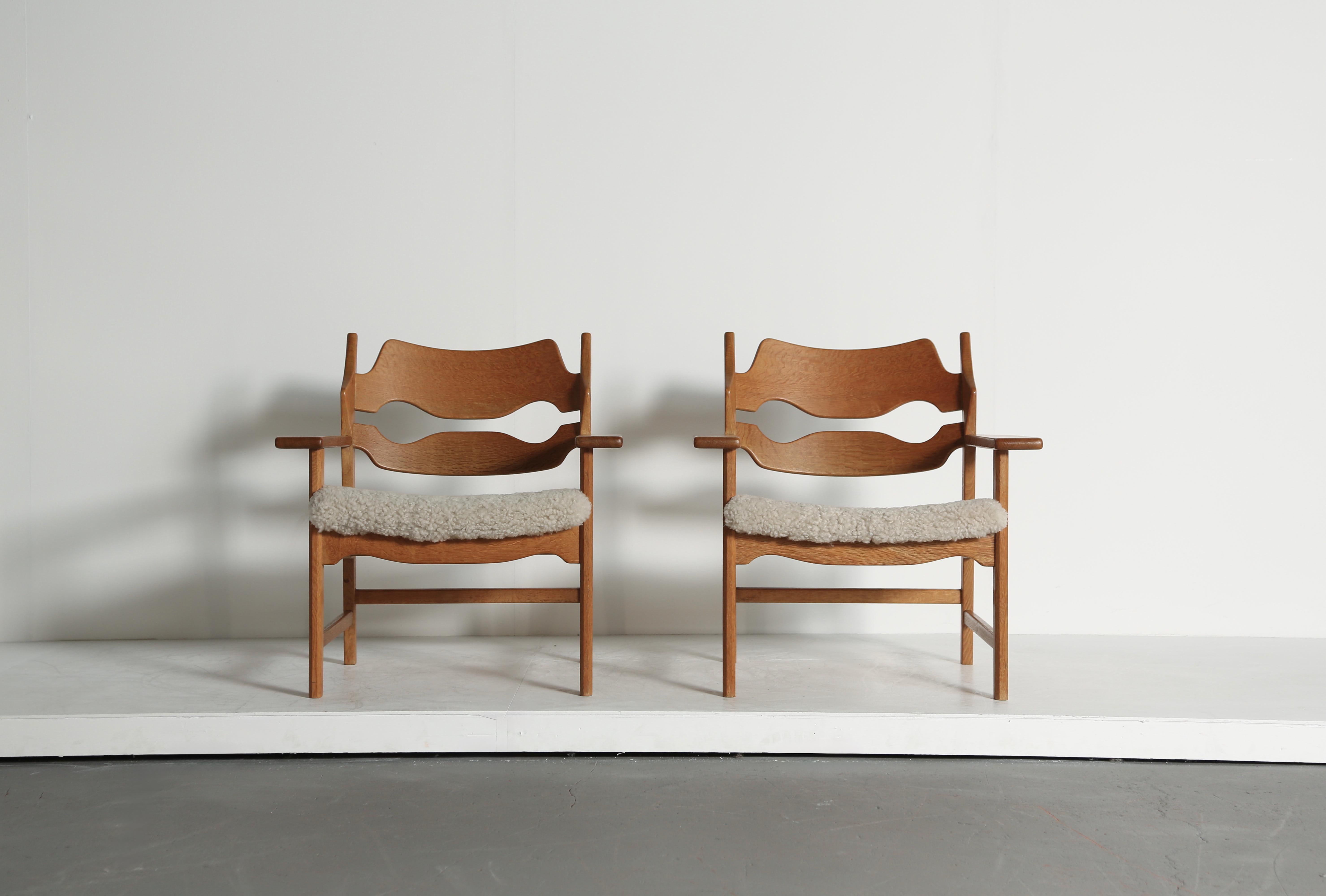 A superb pair of razor blade armchairs by Henning Kjærnulf, Denmark, 1960s. Oak frames in great original condition with a nice even tone and patina. Seats recovered in sheepskin.    Fast shipping worldwide.


