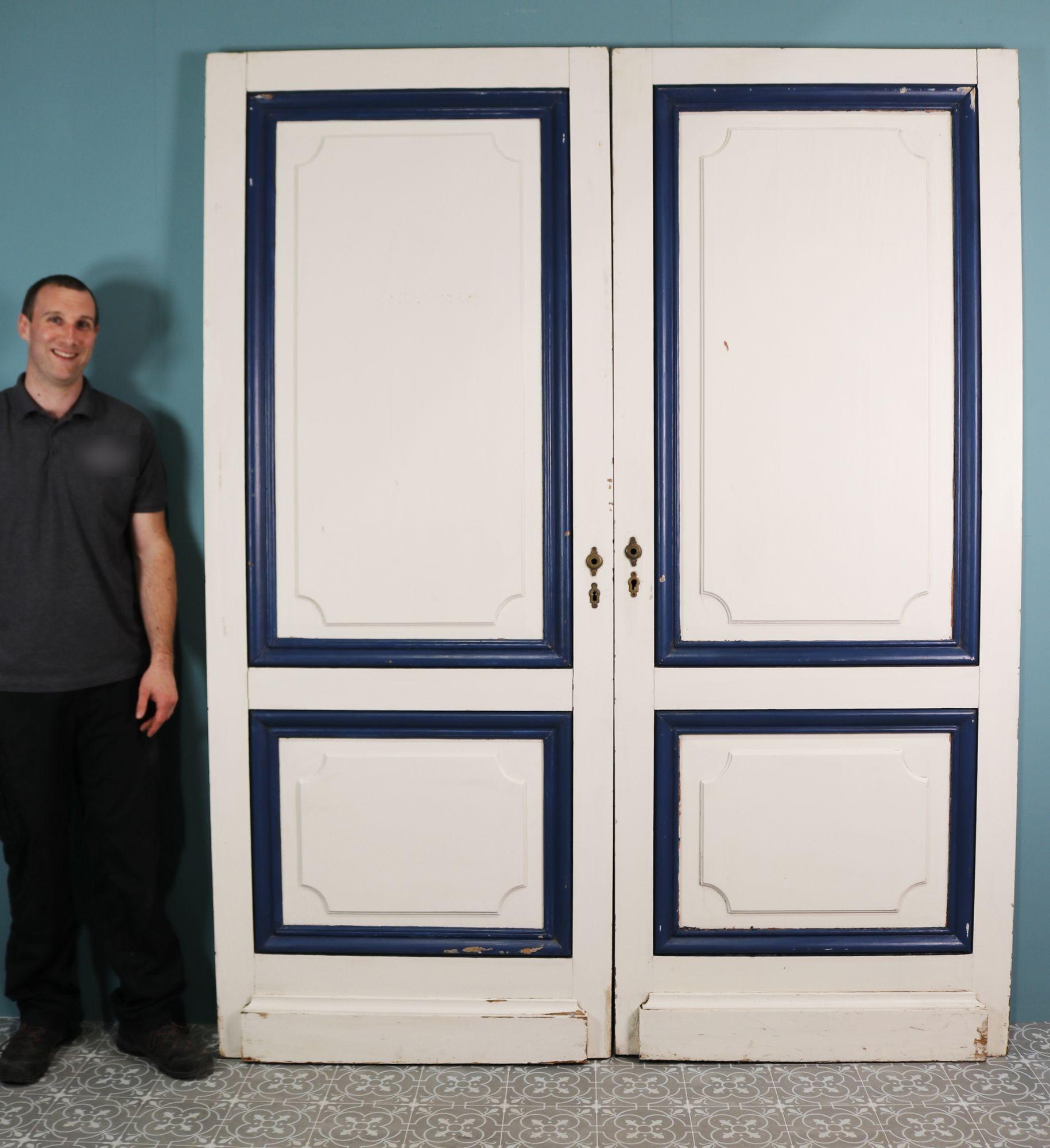 Pair of reclaimed painted double doors. A pair of painted French doors with striking blue and white contrasting colours. The doors feature raised, shaped panels.