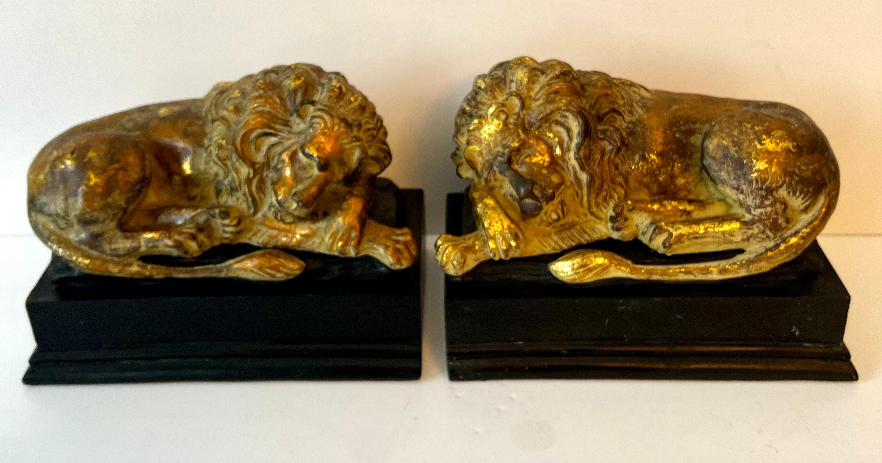 Coppia di leoni reclinabili in foglia d'oro.  La coppia poggia su un'importante base nera ed è piuttosto grande, con un ottimo peso di 3,5 libbre ciascuna.

Un complemento per qualsiasi scaffale o consolle - perfetto per una biblioteca o una tana -