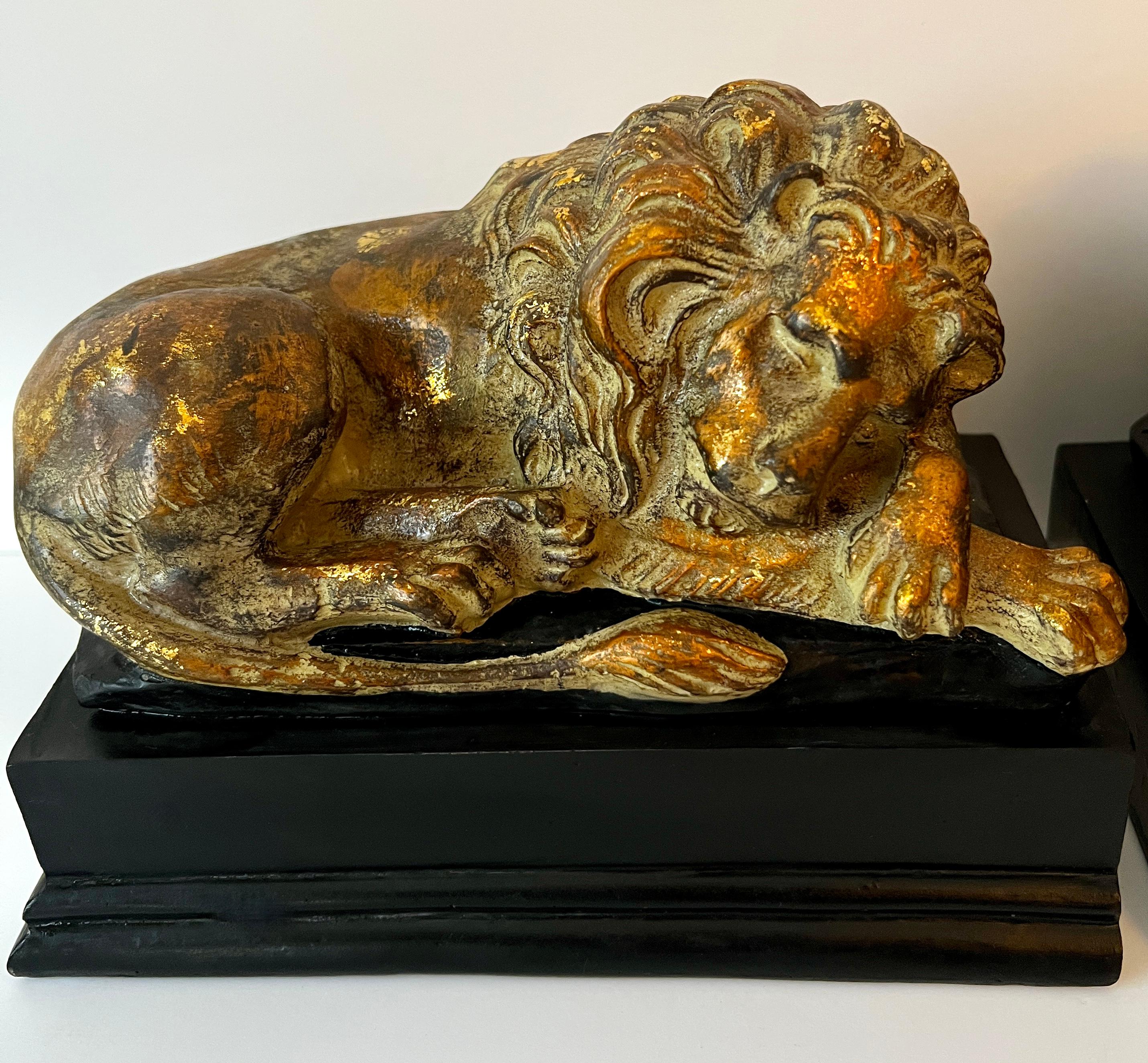 XX secolo Coppia di fermalibri leone reclinabile in legno dorato in vendita