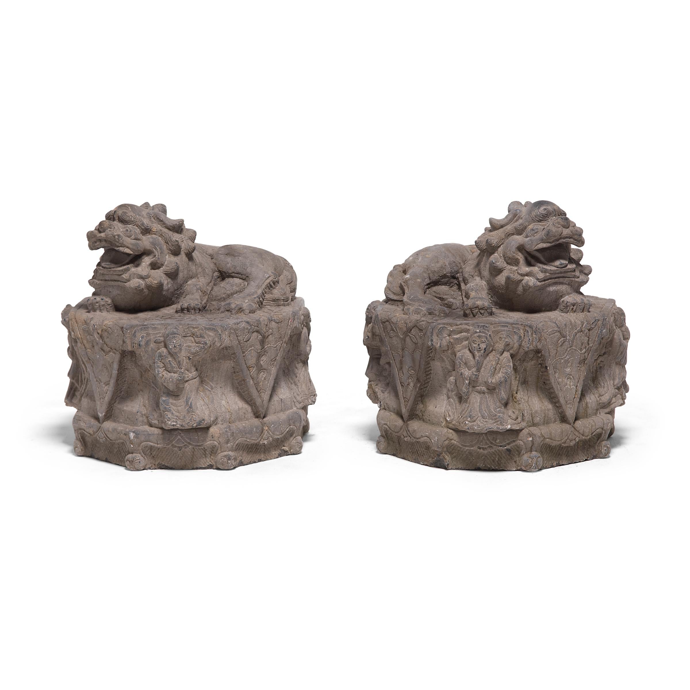 These mid-19th century Chinese Fu dog protectors, each carved by hand from a single block of limestone, once guarded the entrance to a Provincial Chinese residence. They feature mirror depictions of relaxed, reclining lion dogs with flowing manes