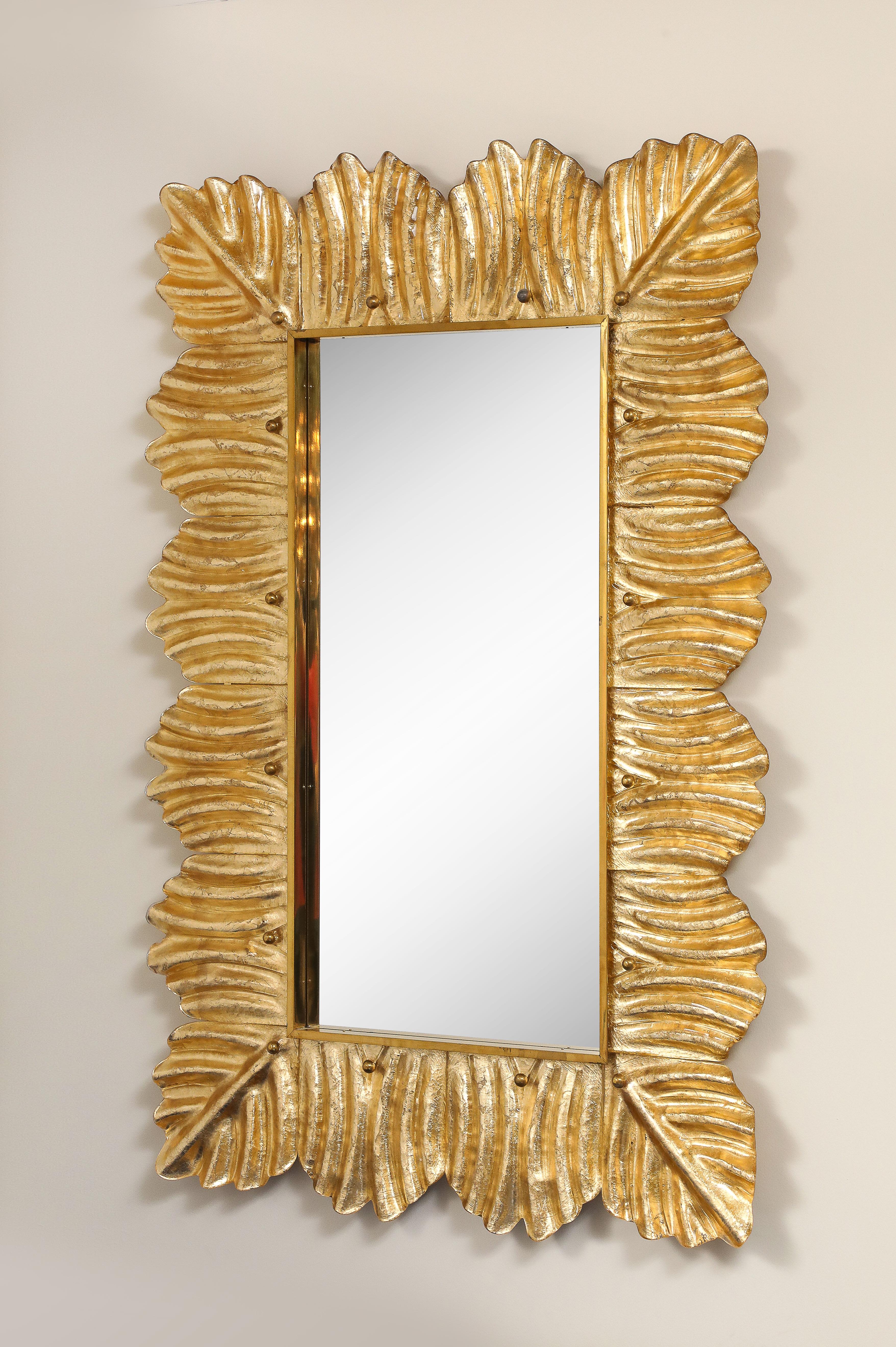 Una coppia di specchi in vetro di Murano radiosi e ricchi di texture, realizzati magistralmente a mano in Italia. Ogni specchio è incorniciato da uno scultoreo vetro di Murano trasparente, dorato a rovescio con una lussuosa foglia d'oro a 23 carati