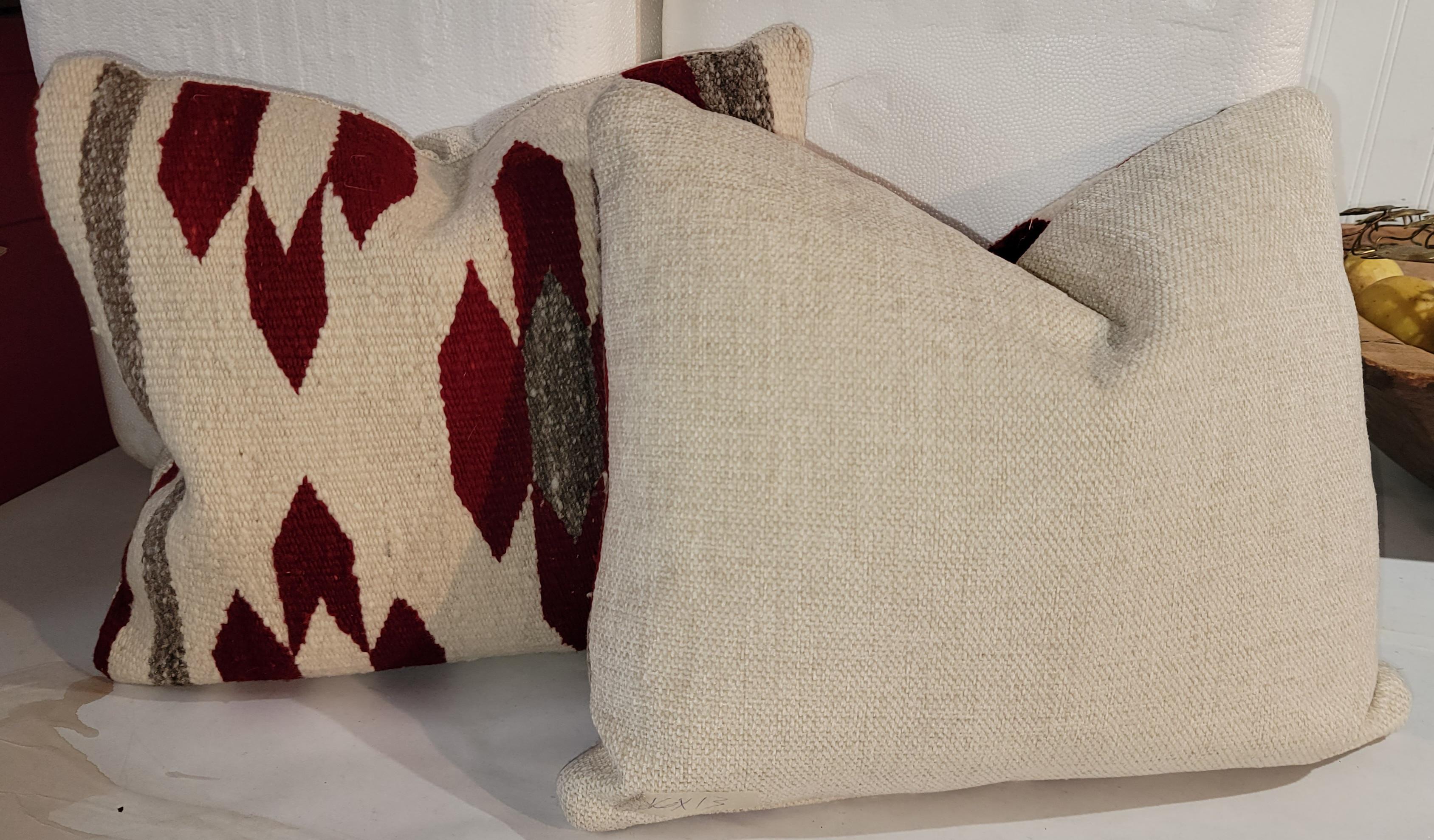 Red and white Navajo chevron pillows with gray stripes. This beautiful pair of pillows has great color in a subtle way. The chevrons are in a four pattern as to make a barrier. The white backing completes the full circle look of the pillows. The