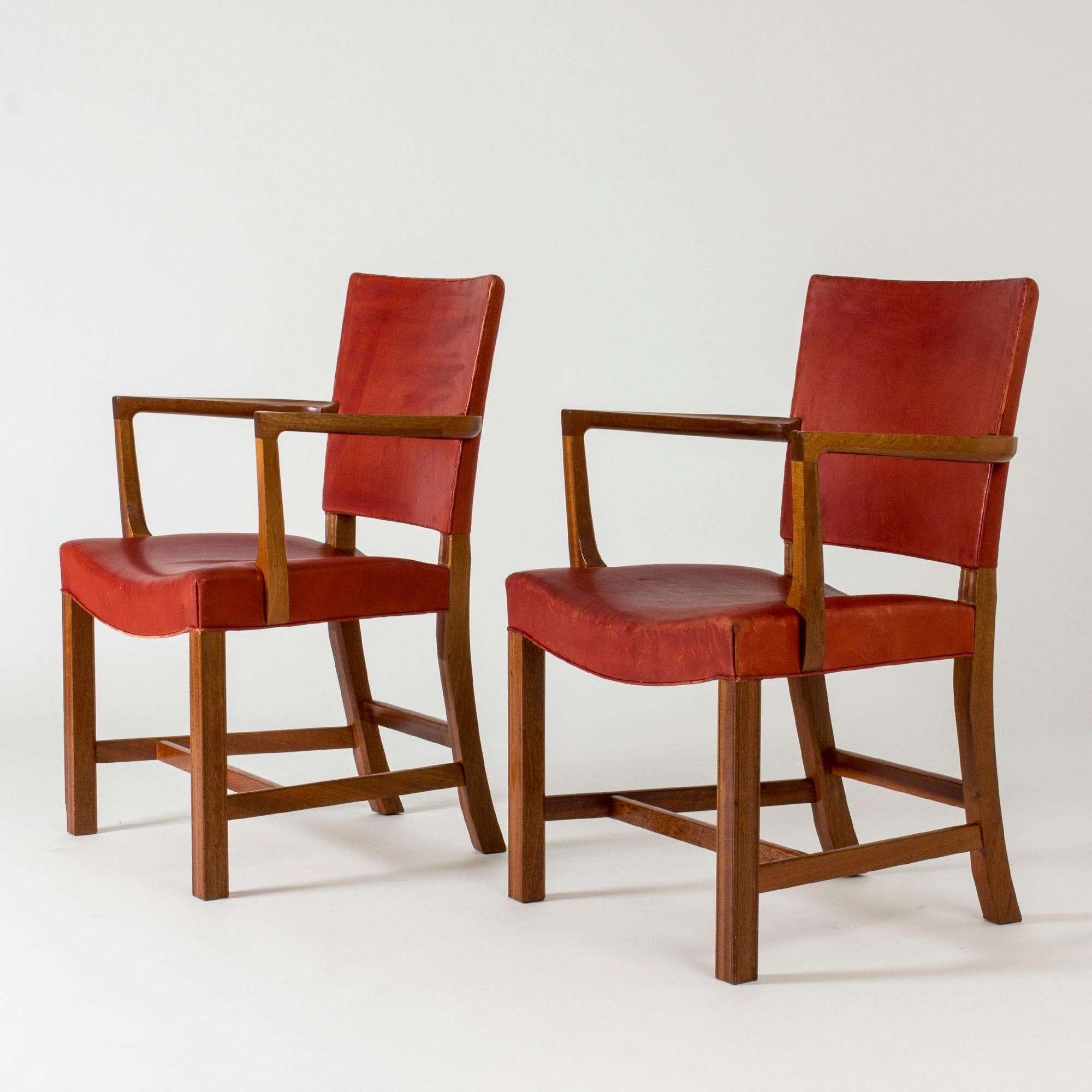 Pair of elegant “Red Chair” armchairs by Kaare Klint, made in mahogany with red leather seats and backs. Sturdy, distinct frames, original leather.