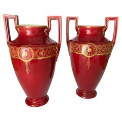 Paire de vases-urnes en cobalt rouge avec poignées en céramique et décorations dorées