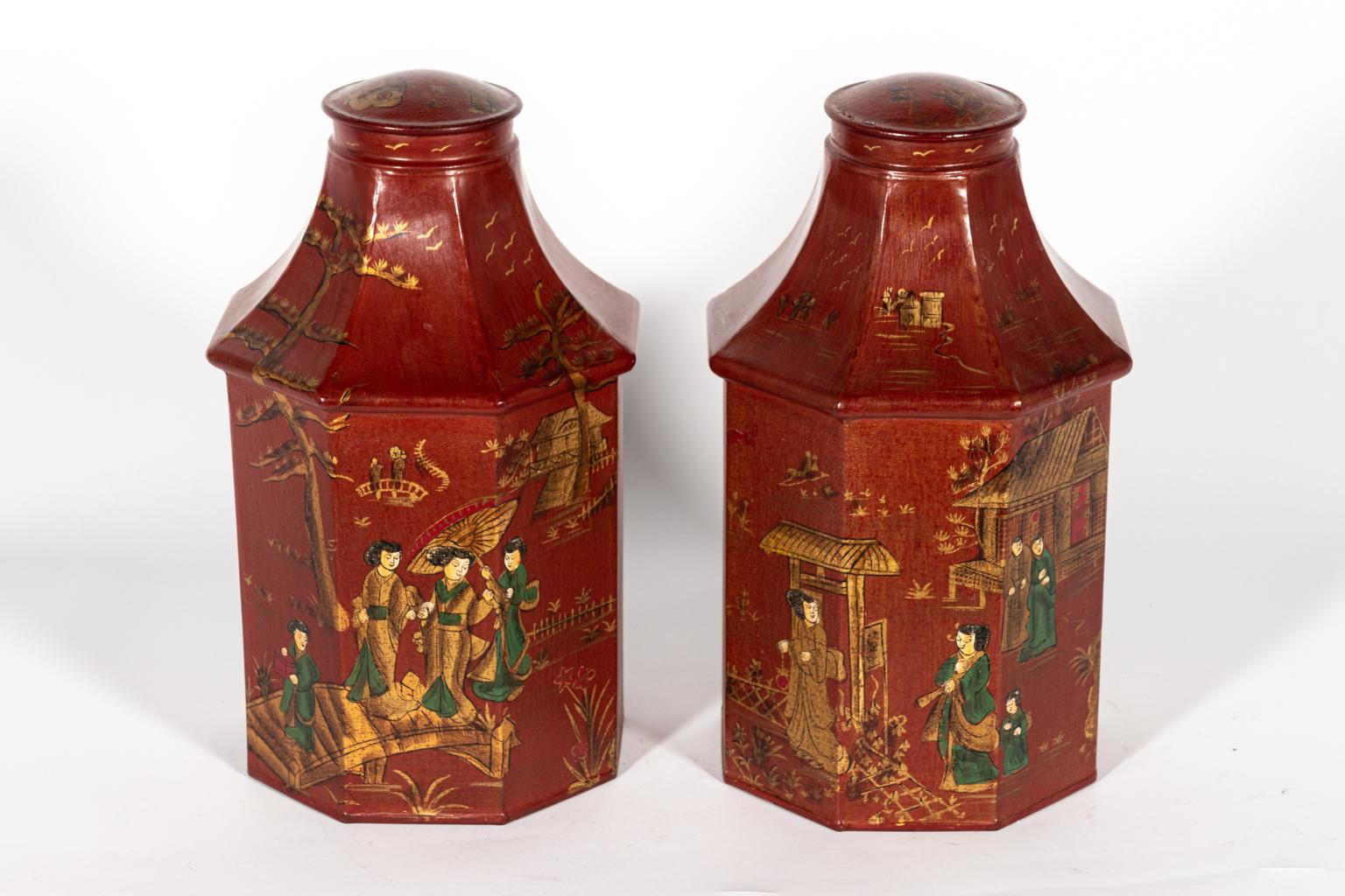 Pair of red decorated tea tins with Chinese style figures detailed throughout. Please note of wear consistent with age including chips and paint loss.