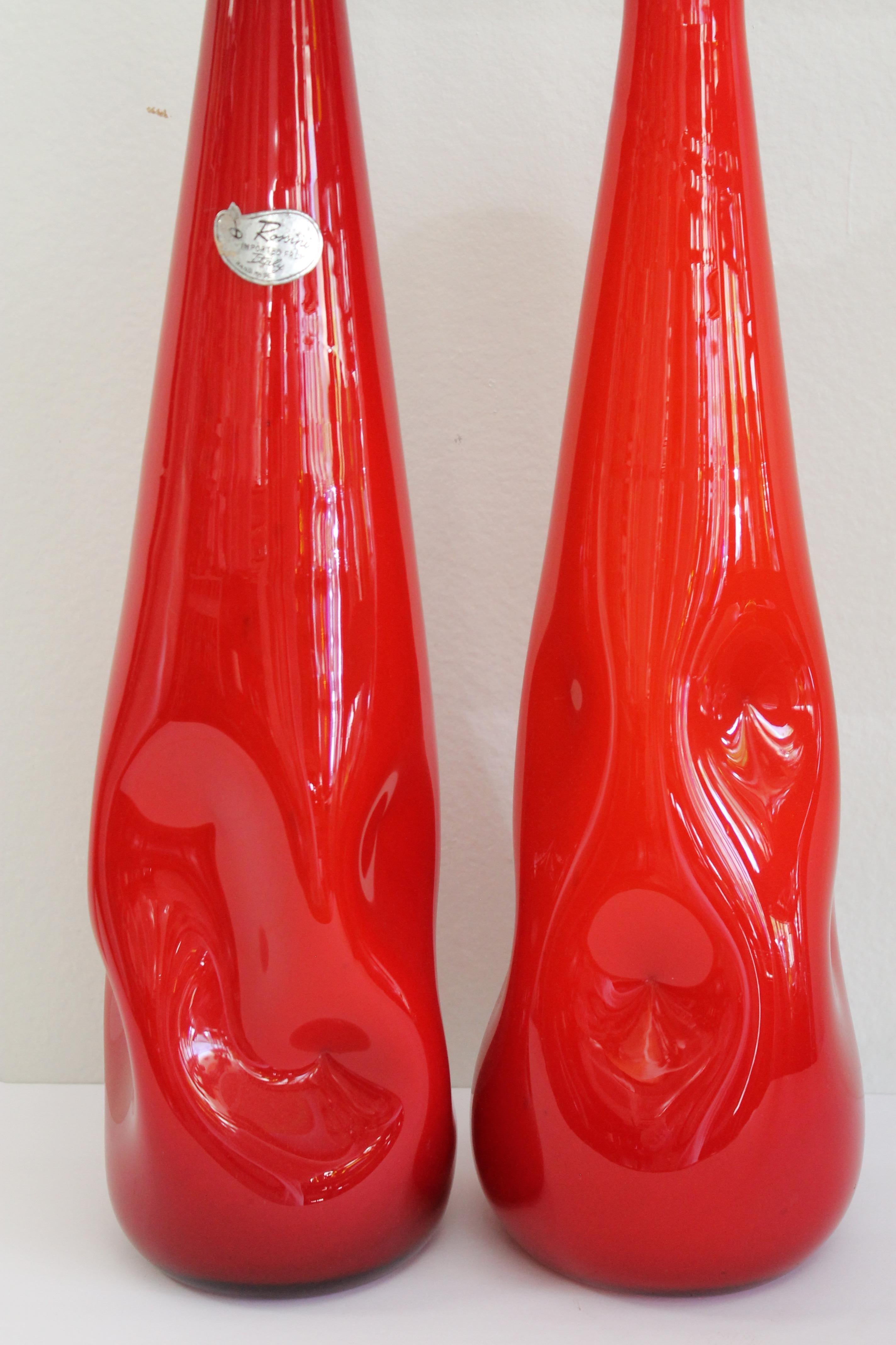 Pair of Italian cased red glass vases. Signed vase is a more red than the other. One vase is signed Rossini Imported From Italy Hand Made. Signed vase measures 21.75