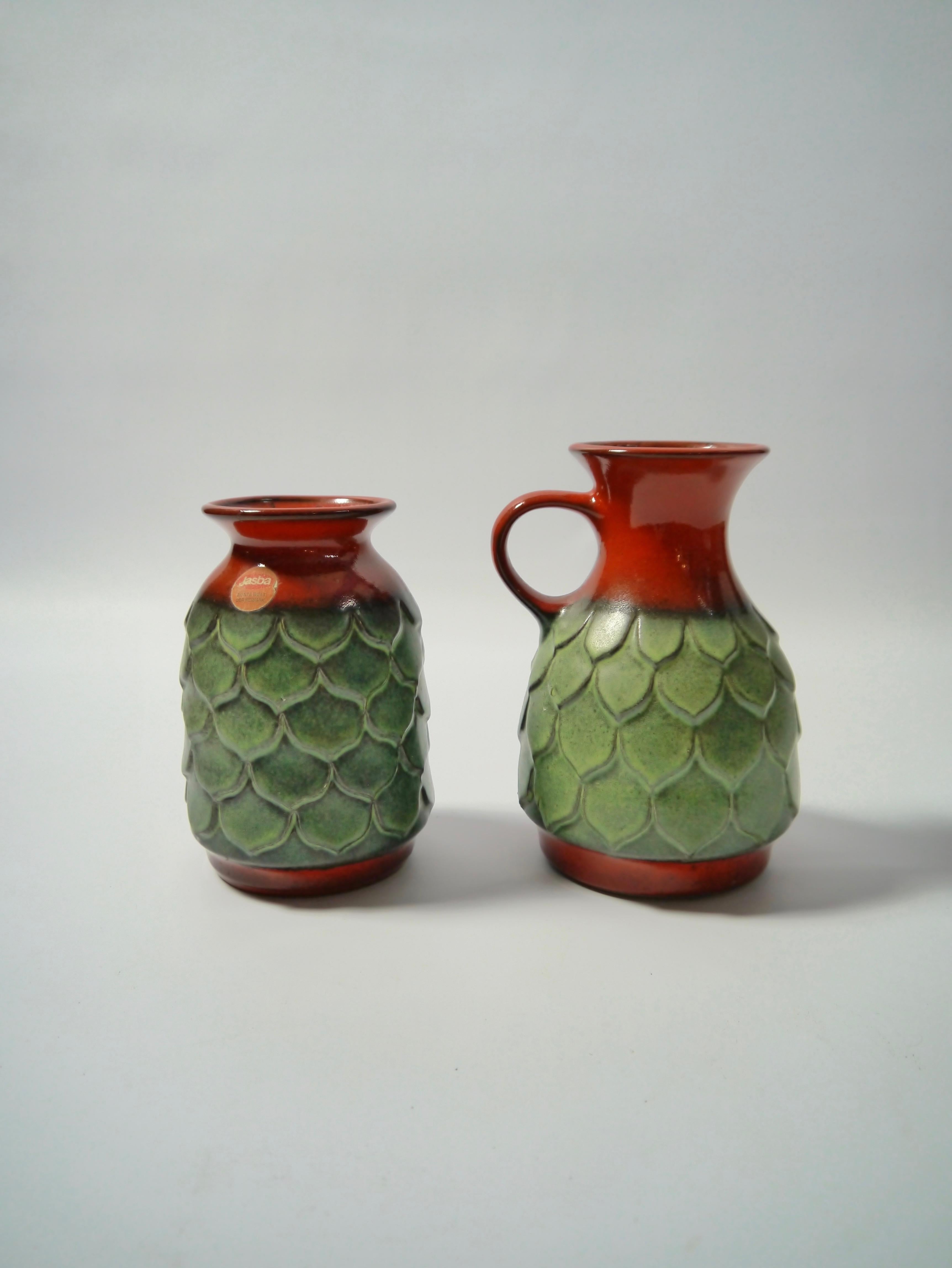 A pair of West German pottery vases fabricated by Jasba. Curios green fisch-scale pattern. One vase retains the original sticker, both marked at the bottom.